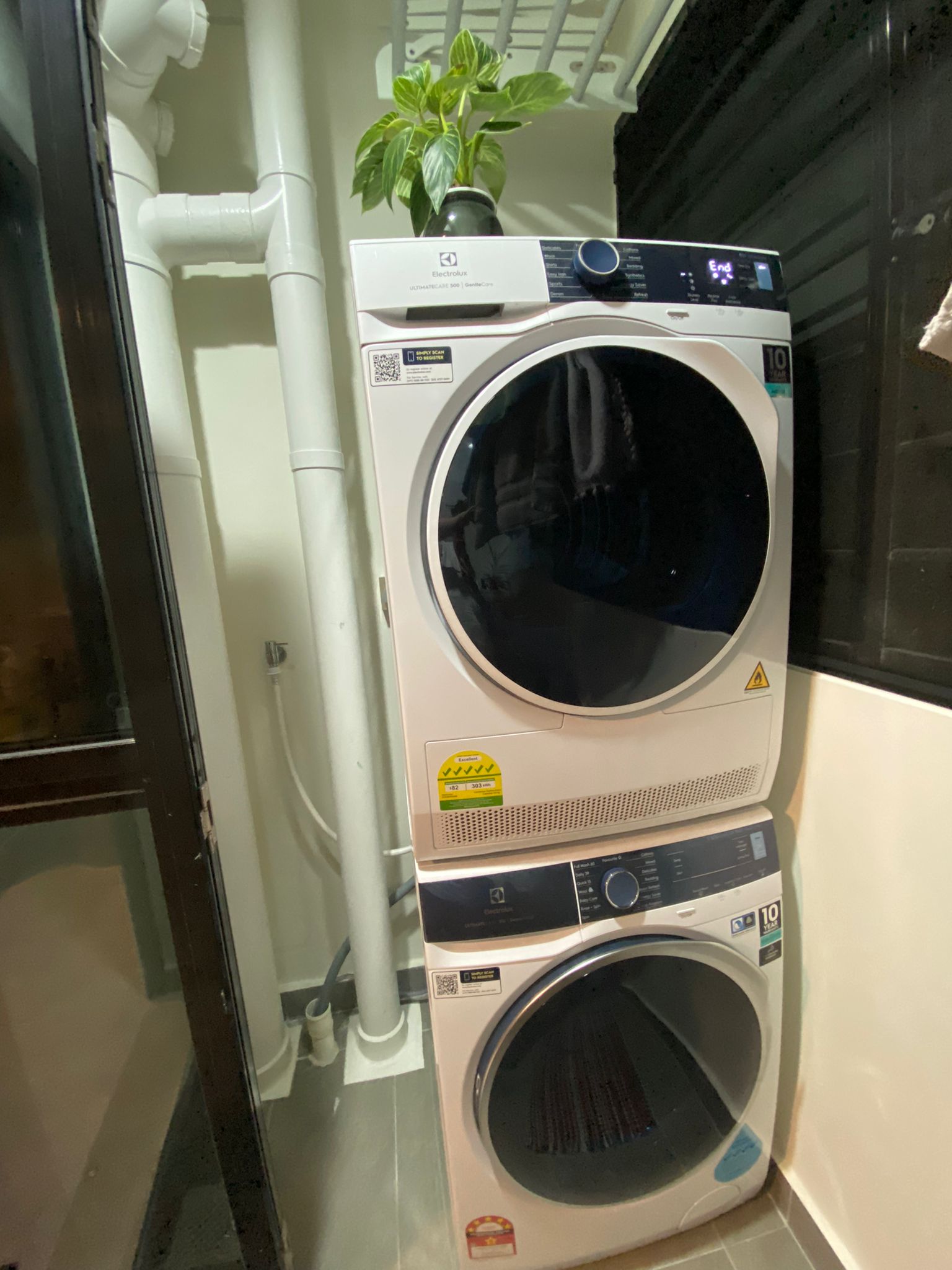 Service yard kept simple, functional and aesthetically pleasing - Dual washer and dryer stacked in a corner, Modern electric