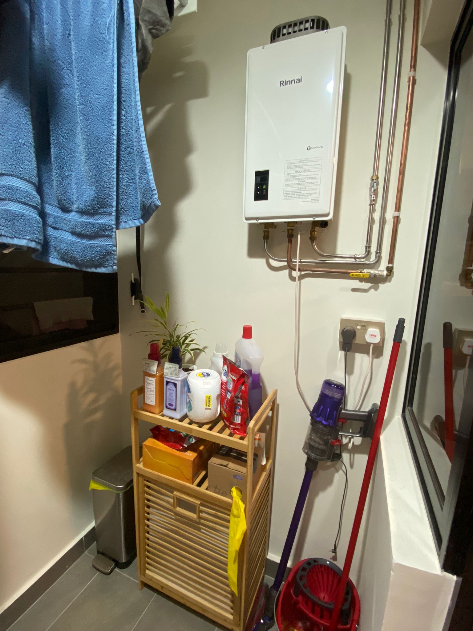 Service yard kept simple, functional and aesthetically pleasing - towel, wall-mounted, water heater, blue towel, plant