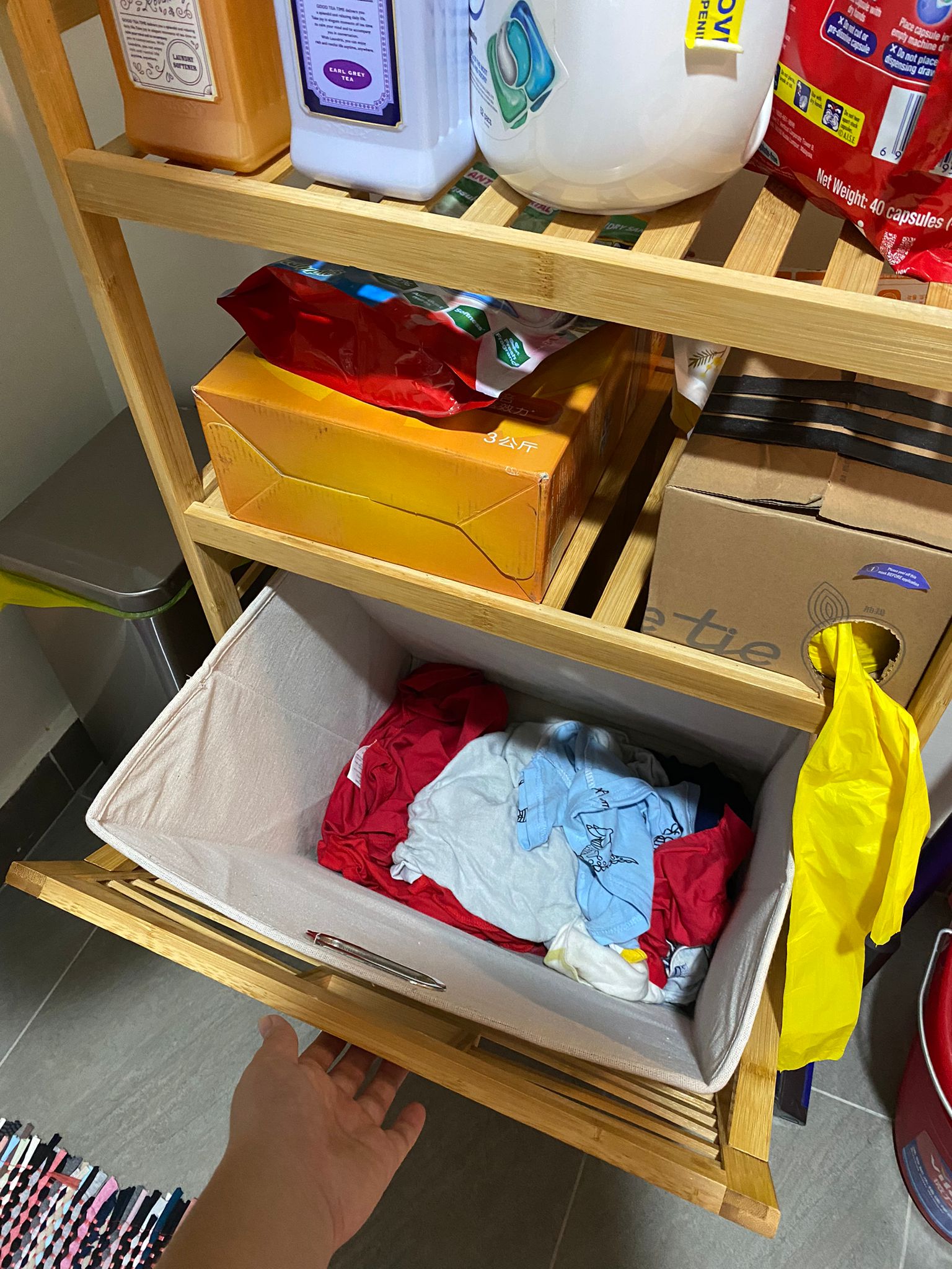 Service yard kept simple, functional and aesthetically pleasing - Wooden shelf, laundry basket, clothes, red and blue shirts