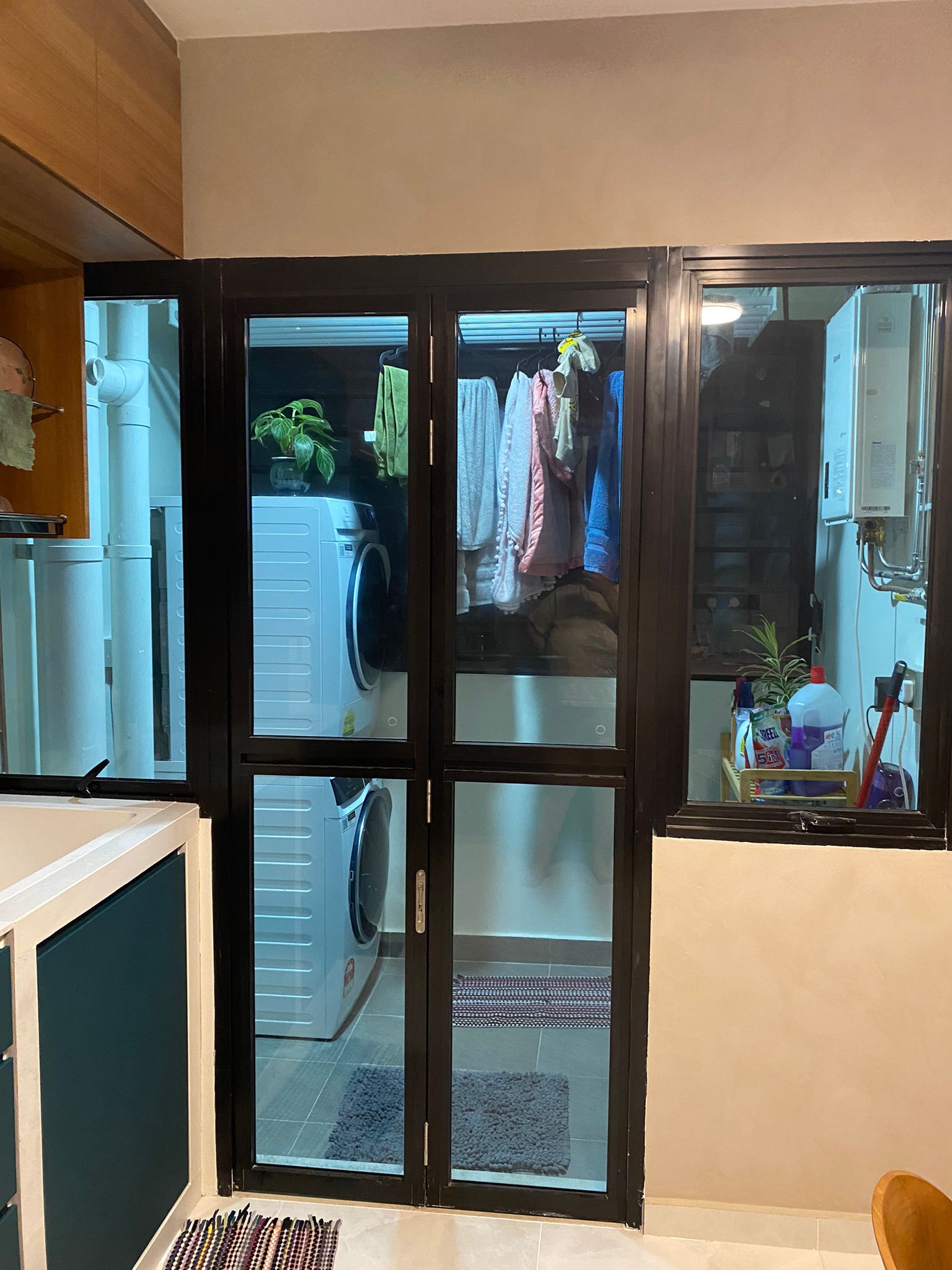 Service yard kept simple, functional and aesthetically pleasing - Glass doors, laundry room, clothes rack, hanging towels