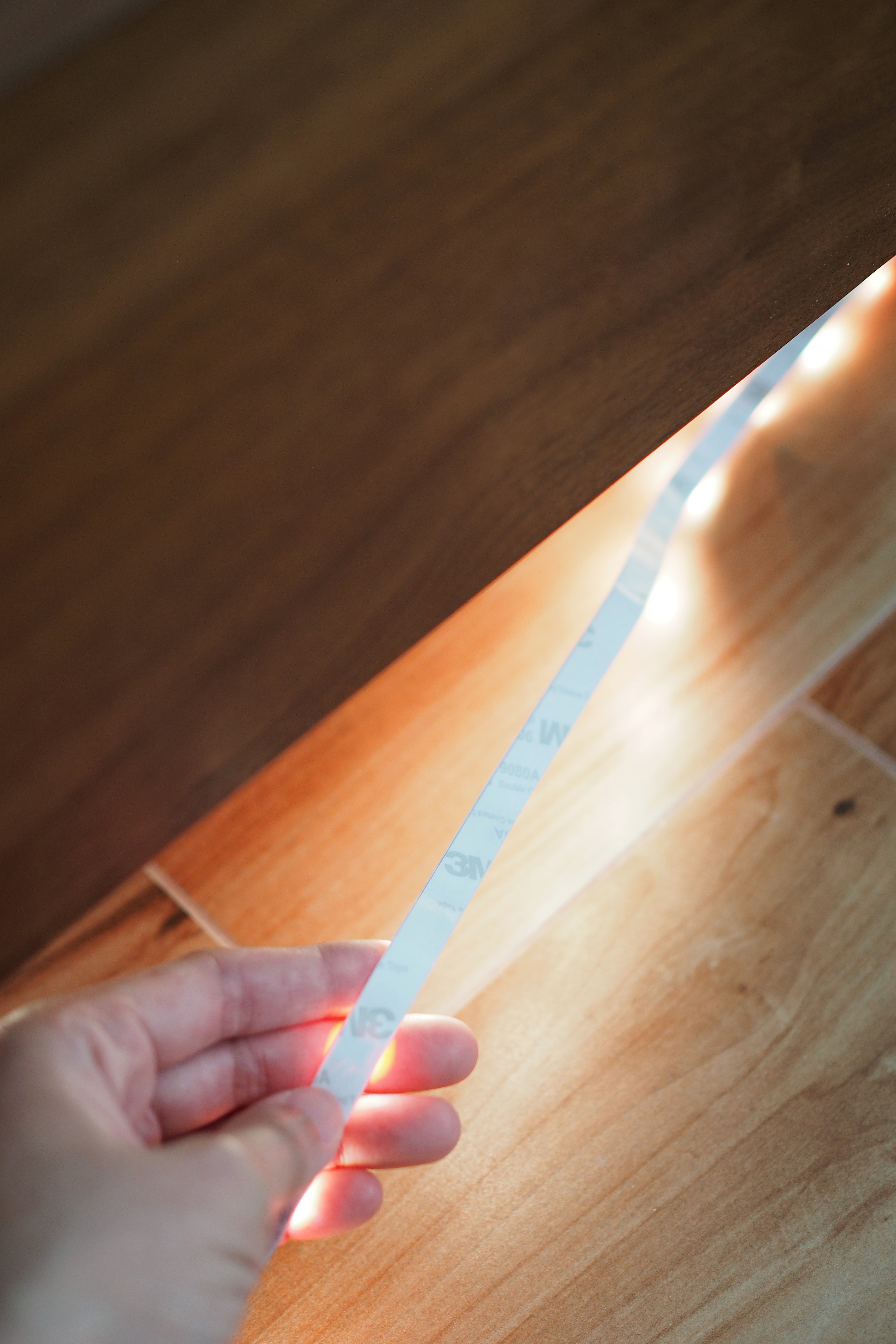 Transform your bedroom with this DIY ‘Floating Bed’ light trick! - wooden floor, measuring tape, wooden surface, hand holding