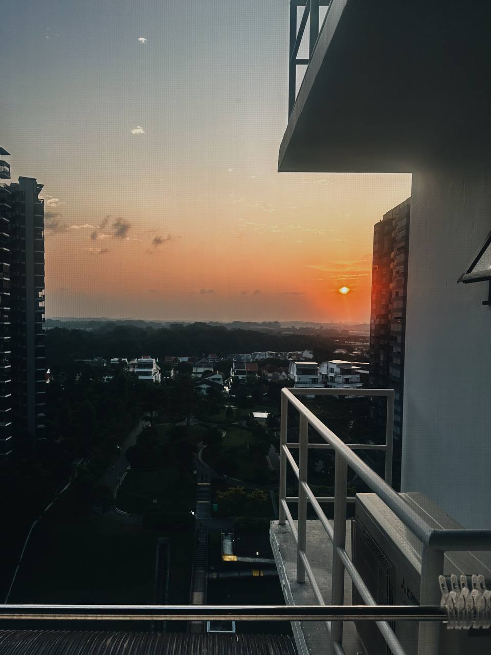 Our Service Yard: Laundry cabinet goals!  - Sunset over cityscape, tall buildings, sunset sky, warm orange hues, distant
