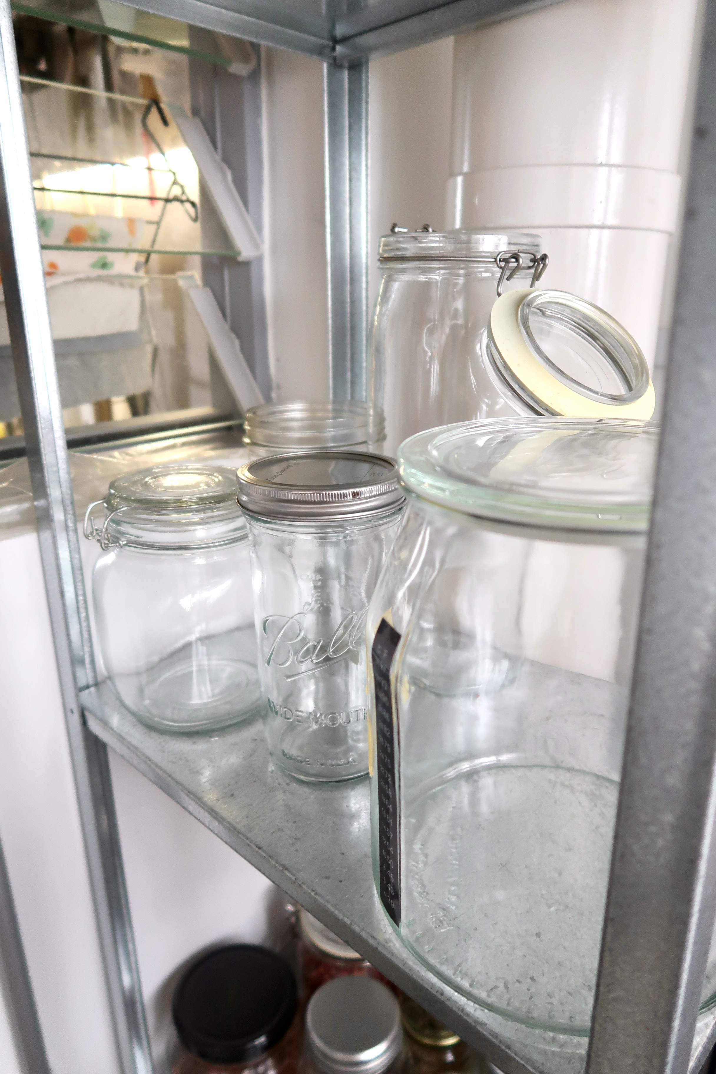 Multi-Use Service Yard with a Fermentation Nook  - Glass jars with metal lids on metal shelves, neatly arranged, glass jars