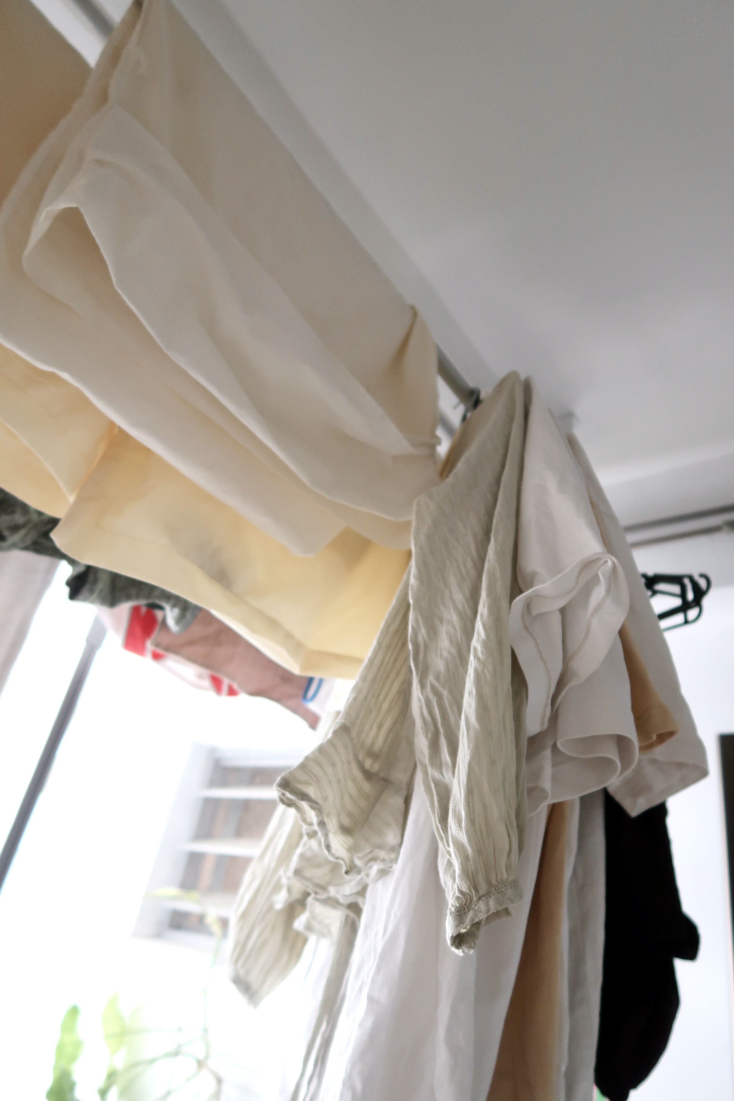 Multi-Use Service Yard with a Fermentation Nook  - Soft, cream-colored garments hanging on a rack, natural light streaming