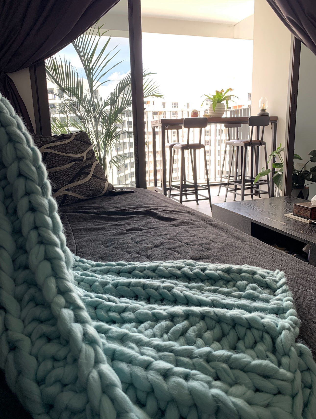 Our 10sqm Balcony: Outdoor Oasis That Makes Our DBSS Look Like A Condo - Turquoise cable-knit throw blanket, cozy bed, modern