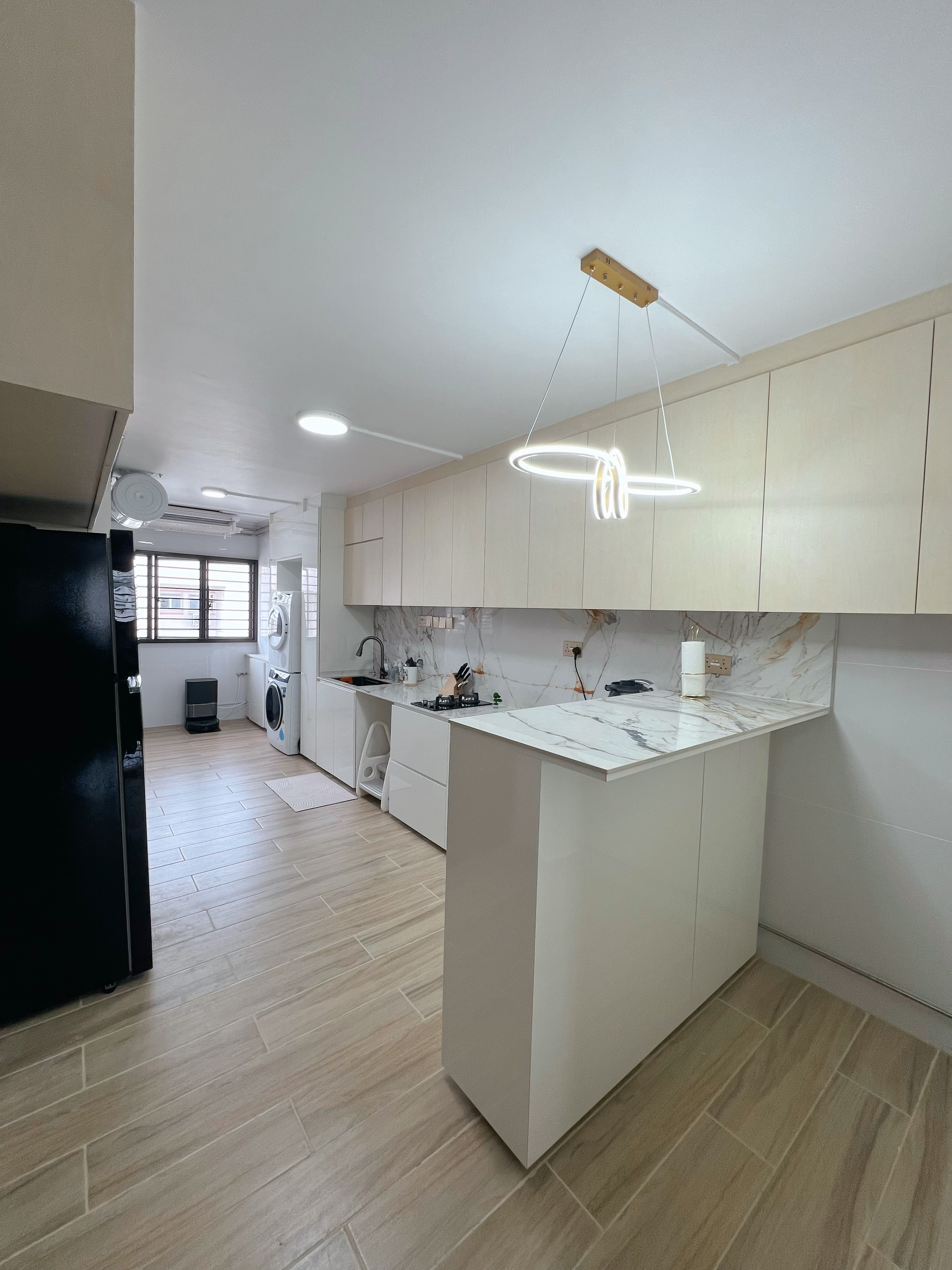 An Unconventional take on a HDB Jumbo Service Yard perhaps? - Modern kitchen with sleek white cabinetry, marble countertops