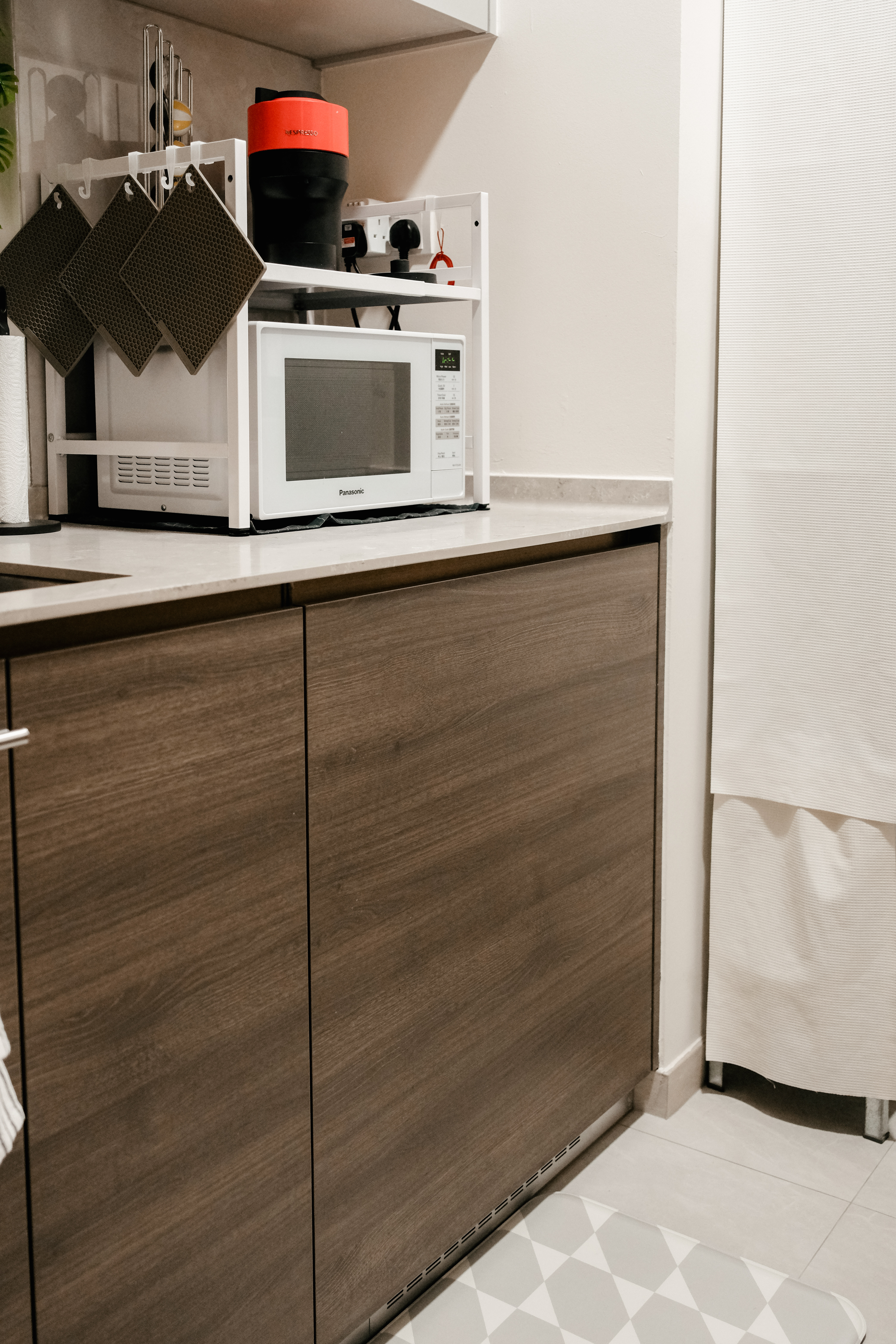 The ultimate space-saving solution in our minimalist rental apartment! - Kitchen countertop, microwave, white cabinets