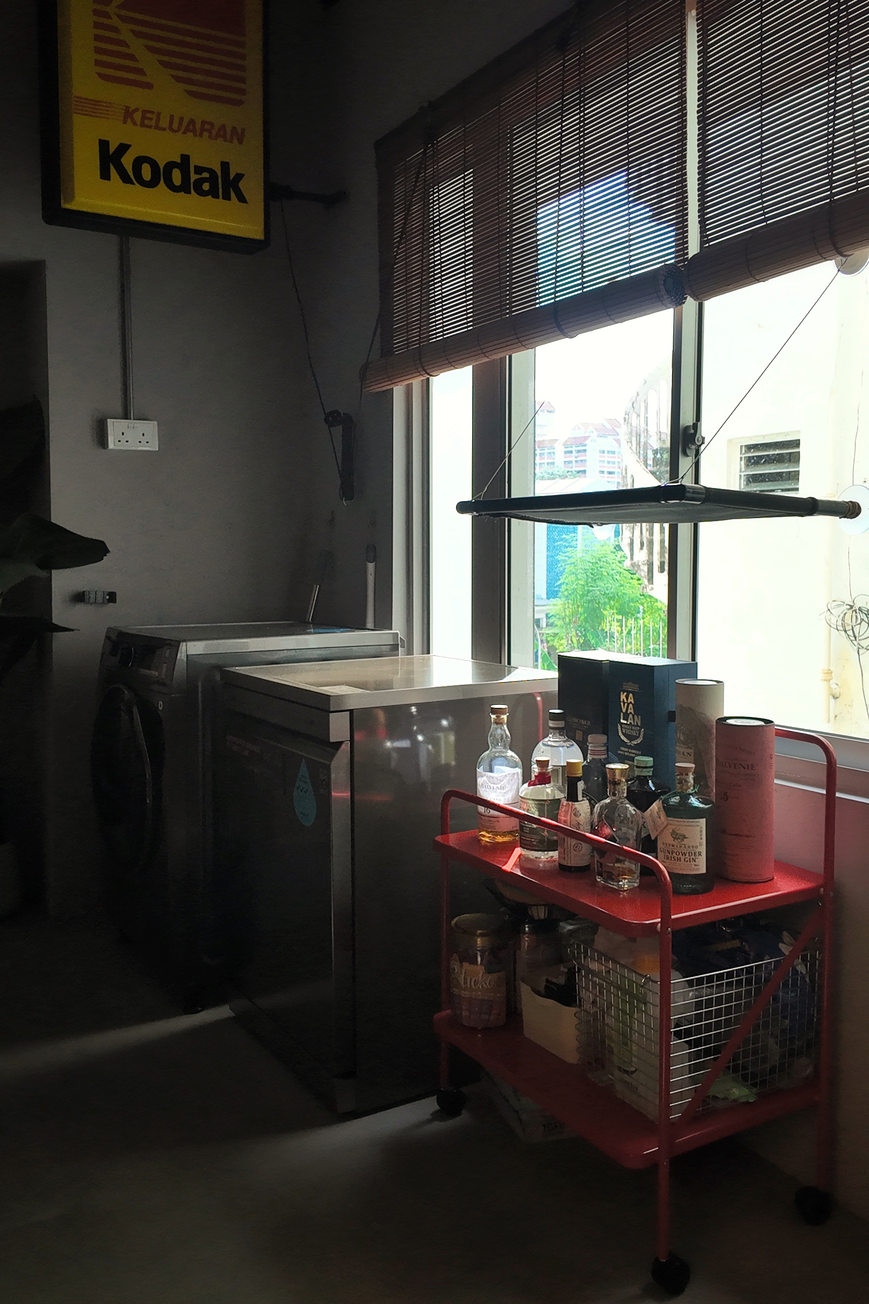 Service Yard//Cat Kingdom? - Dedicated space for storing liquor, red cart filled with various bottles, Kodak sign on the