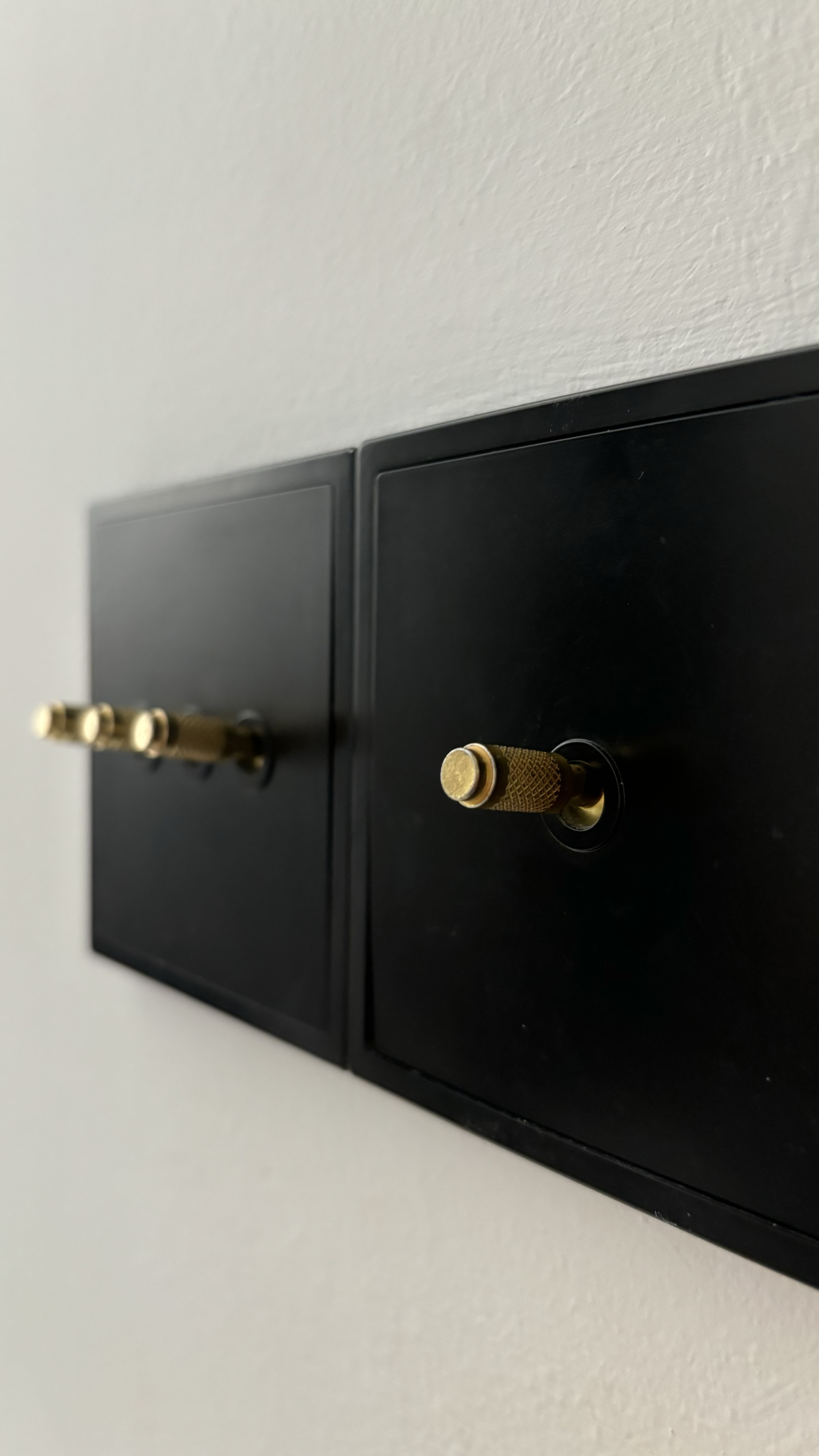 Easy ways to up your home aesthetic game! - Black wall-mounted electrical outlets with brass handles, sleek modern design