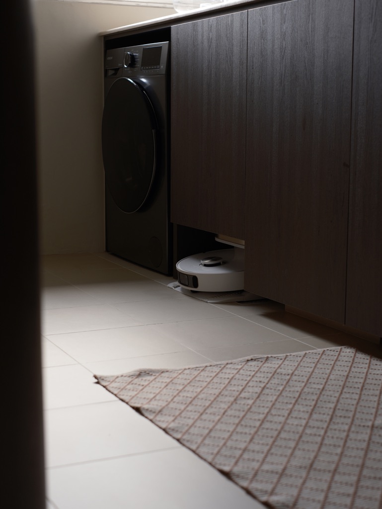 Service Yard: Laundry and Plant corner - Dedicated space for laundry, modern washing machine, dark wooden cabinet, robotic