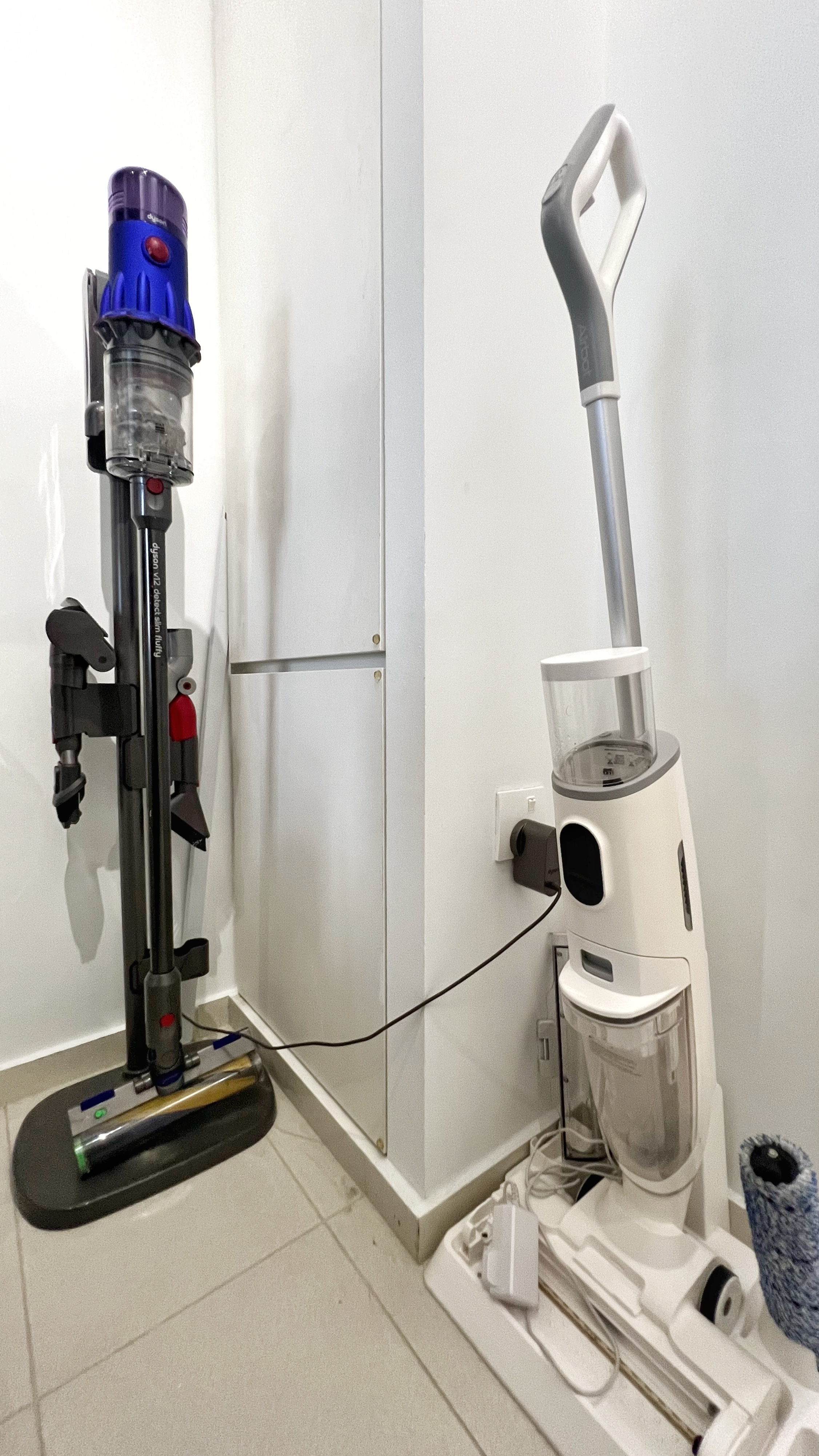 The Unsung Heroes: Where the Magic of Cleanliness Happens - Dedicated vacuum cleaner, upright stand, blue top, red button