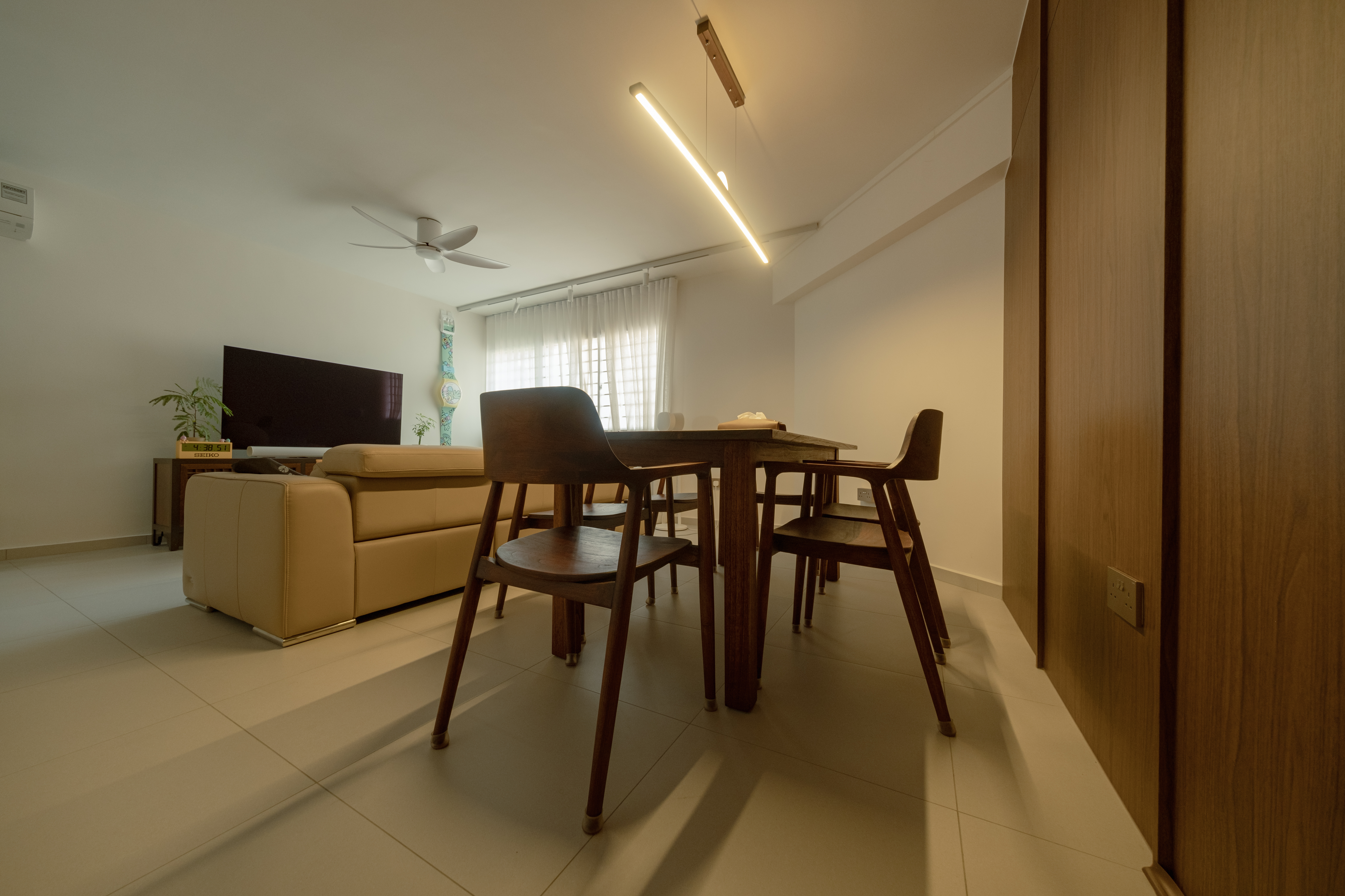 10  Months On: Our Best Home Purchases! - Modern living room with beige sofa, wooden dining table and chairs, ceiling fan