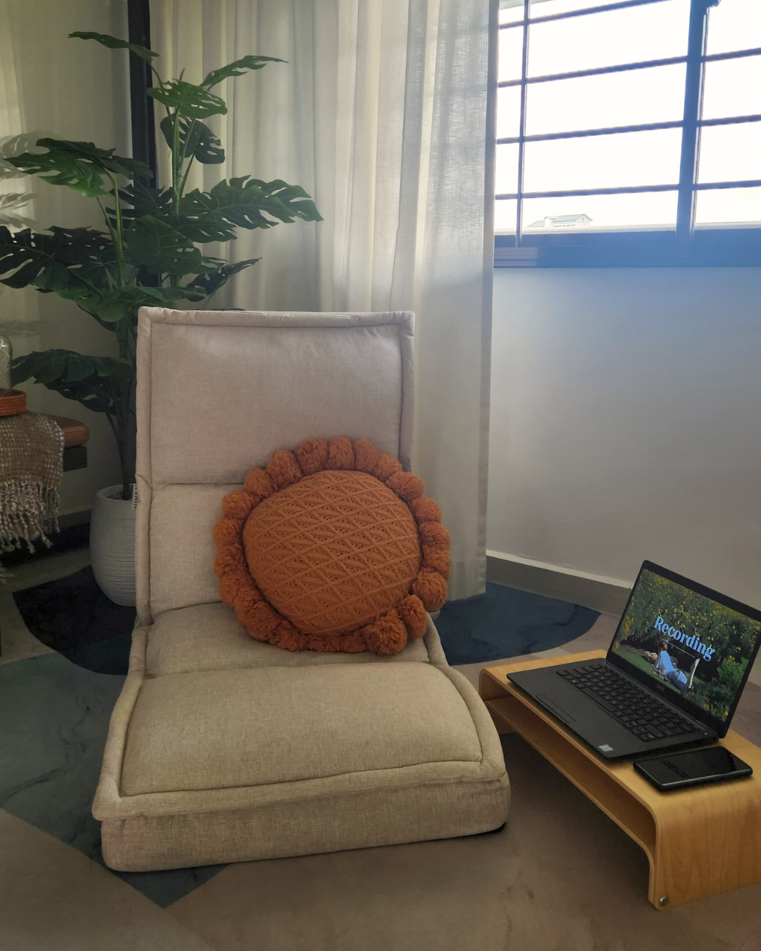 Our Cozy Area: 3 Ways Comfort Meets the Ground - Laptop on wooden coffee table, orange crocheted pillow on beige chair
