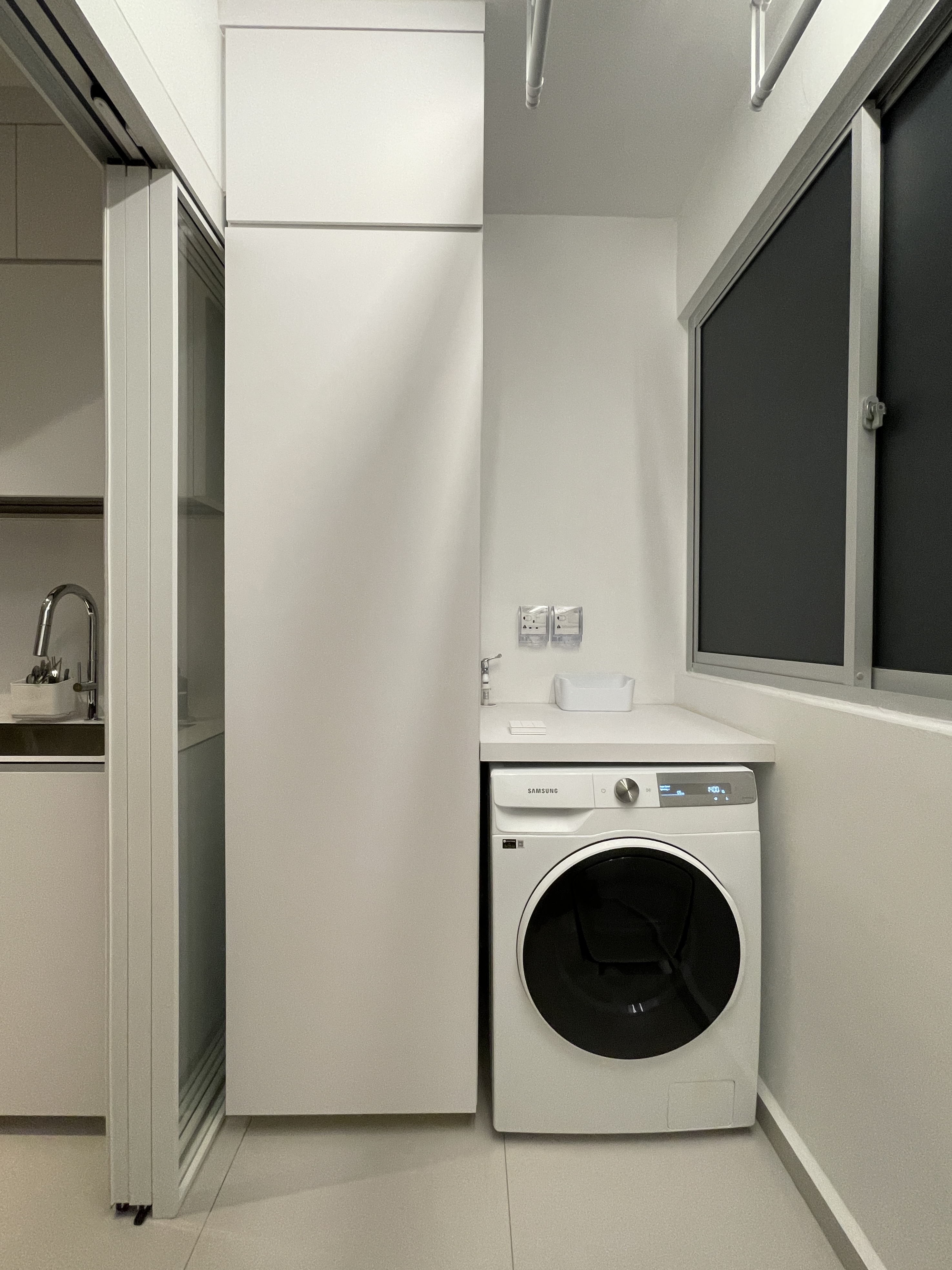 Service Yard: Clean, Spacious and Minimalist  - Modern laundry room, compact space, white cabinets, sleek design, built-in