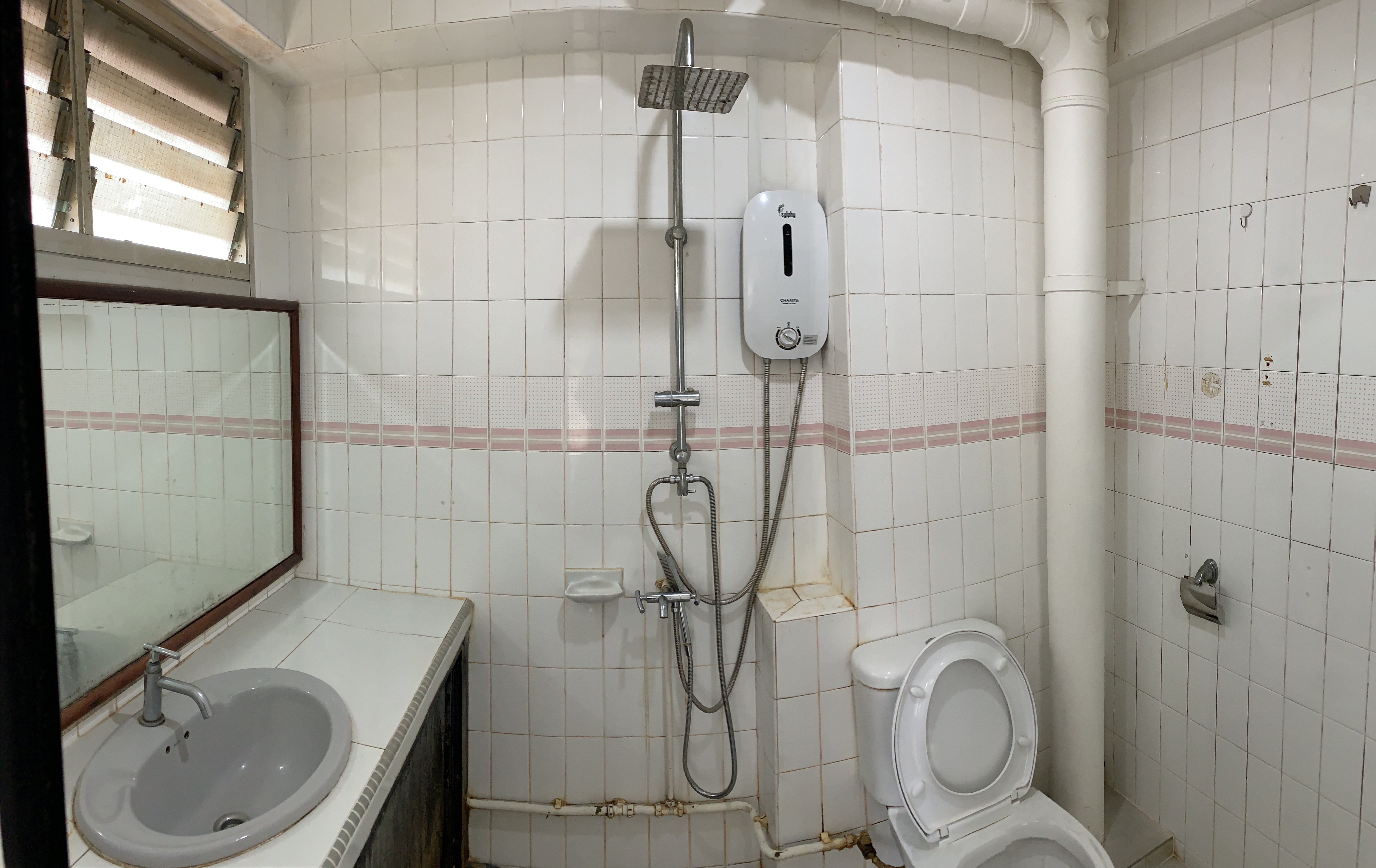 We regretted not doing this during our Bathroom Reno - White tiled bathroom, showerhead, toilet, sink, mirror, window with