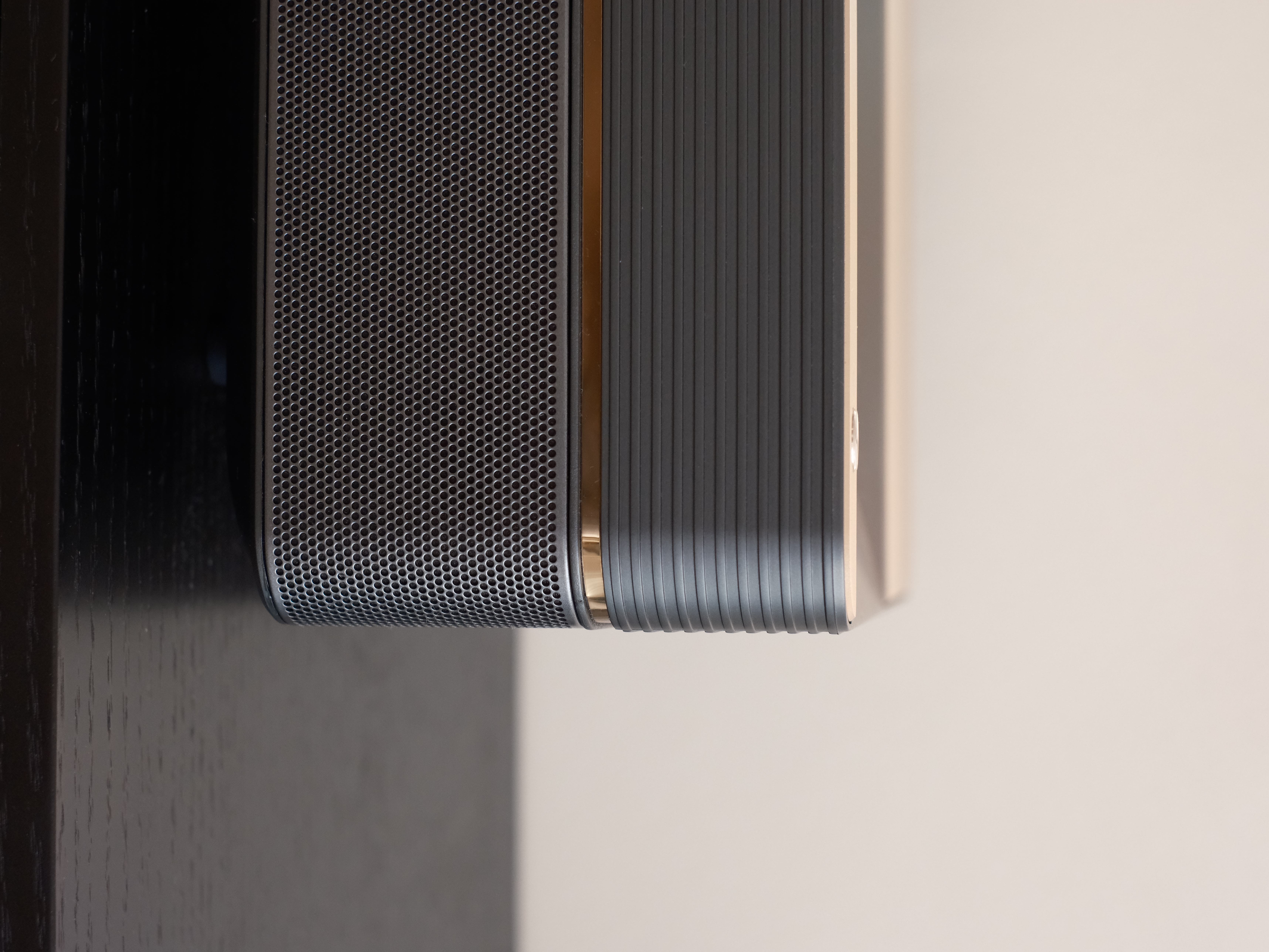 Why We're Obsessed with our Projector: The Best Home Investment - Black and gold speaker grille, sleek design, perforated