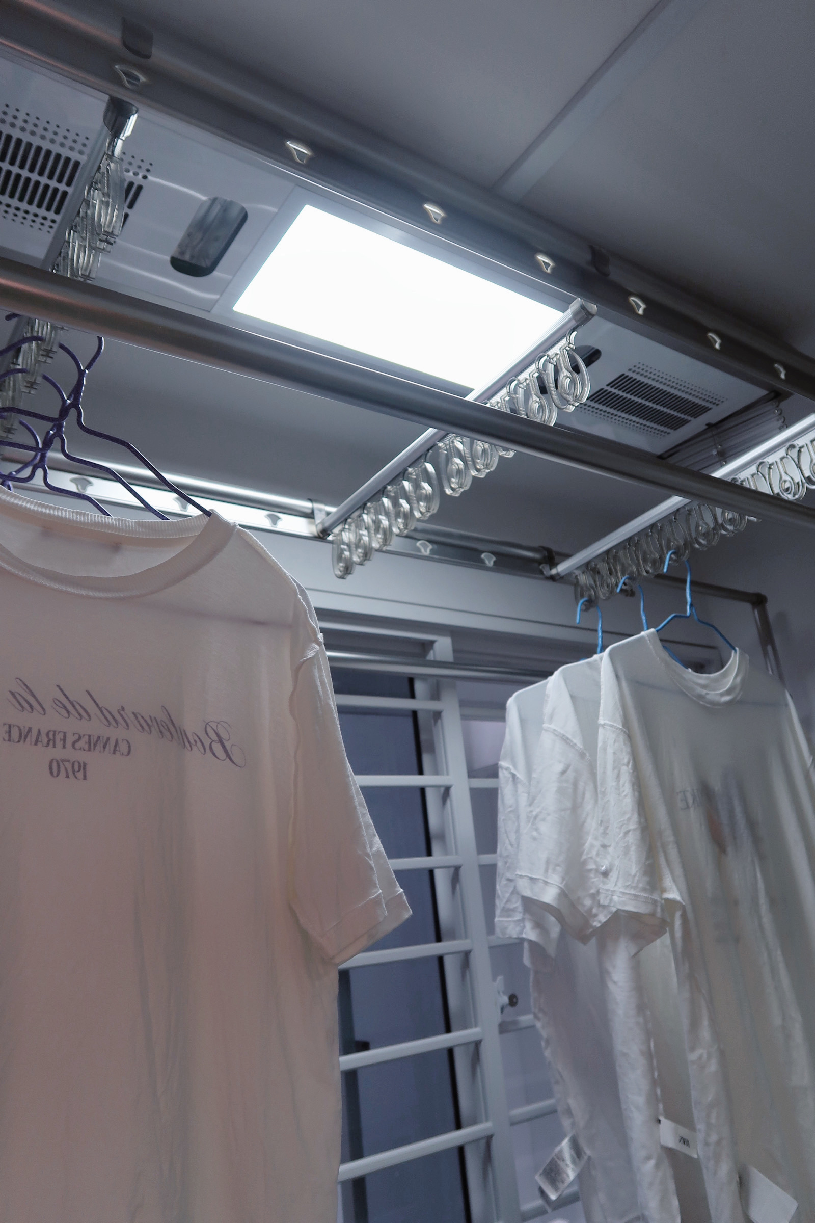 Our Service Yard: Ideas for Small Laundry Area 🧺 - White T-shirt with text, hanging on a rack, metallic interior, ceiling