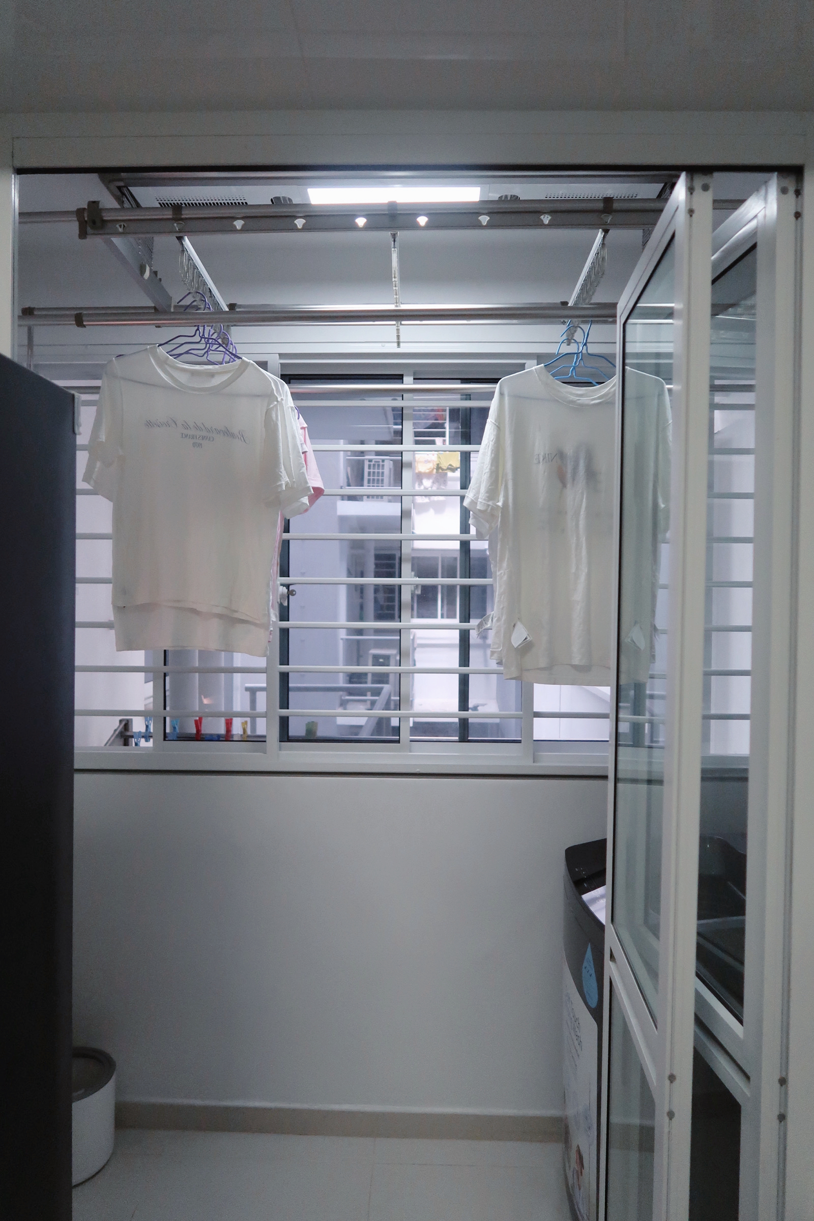 Our Service Yard: Ideas for Small Laundry Area 🧺 - White t-shirts hanging on racks, window with metal bars, fluorescent