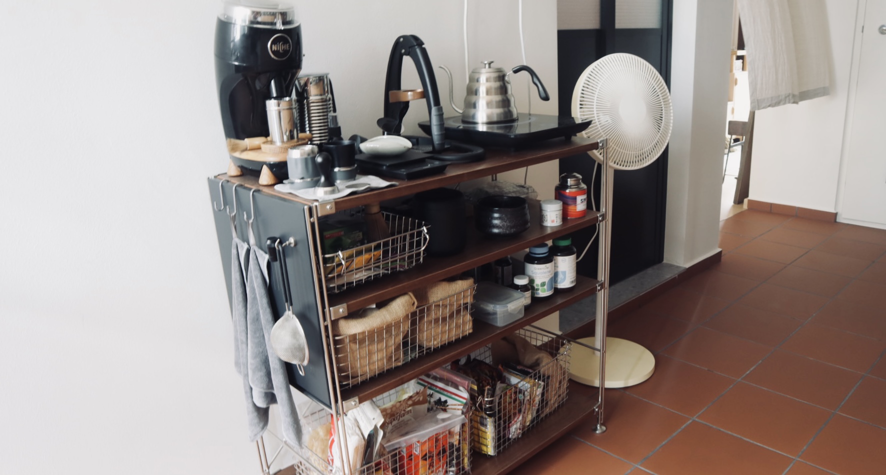 to each their own space - organisation for galley kitchen - coffee maker, stovetop, kettle, fan, shelves, baskets
