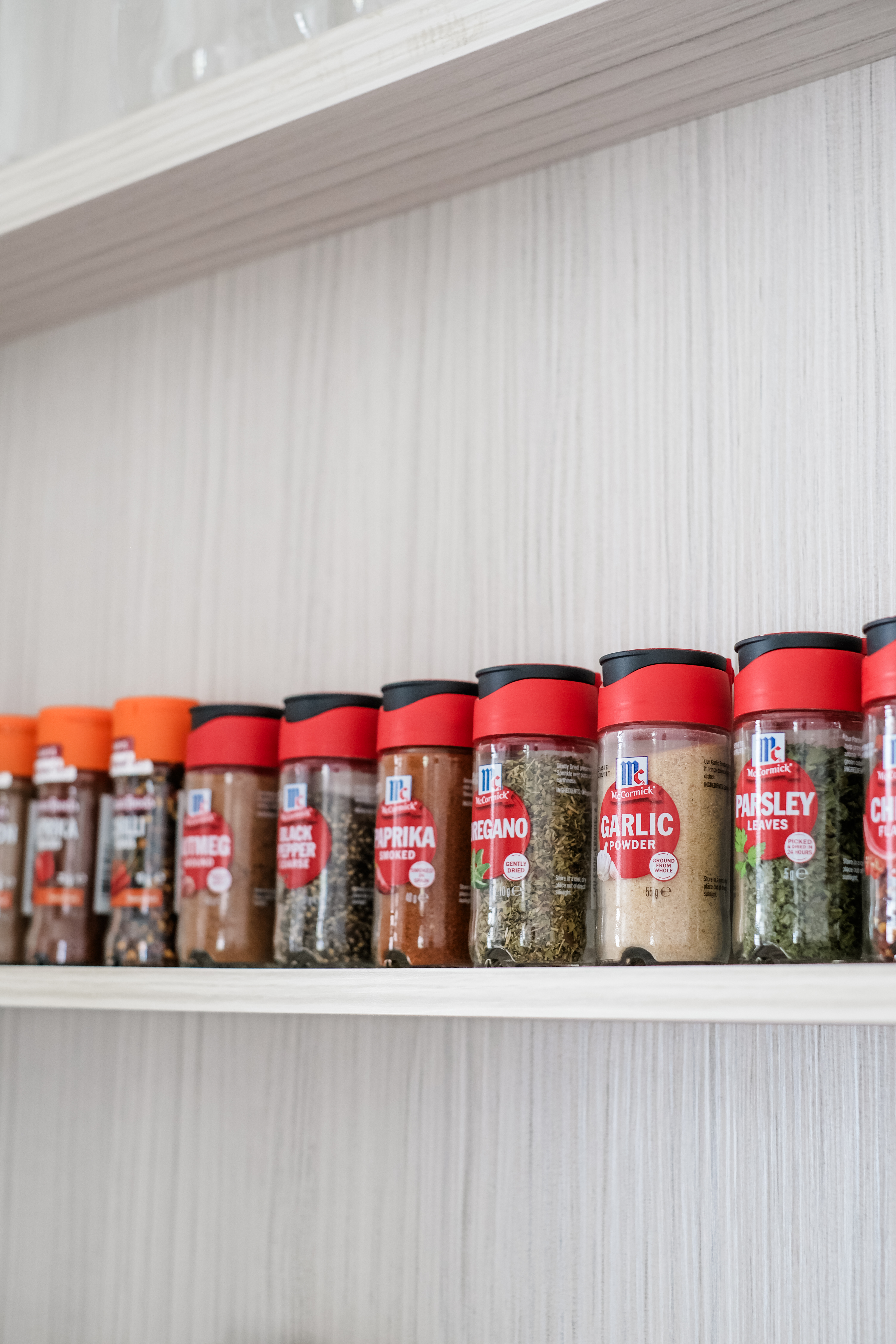 Effortless Kitchen Organization : Keep It Clean and Clutter-Free - Organized spice jars, red and black lids, McCormick brand