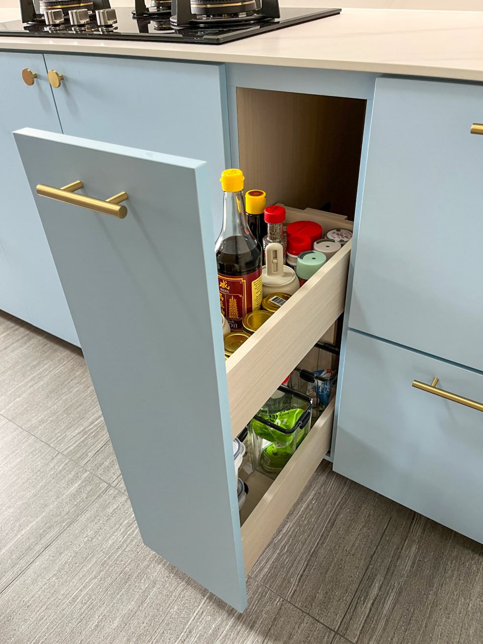 A peep into our kitchen cabinets!  - Light blue kitchen cabinets with gold handles, open pantry drawer, various condiments