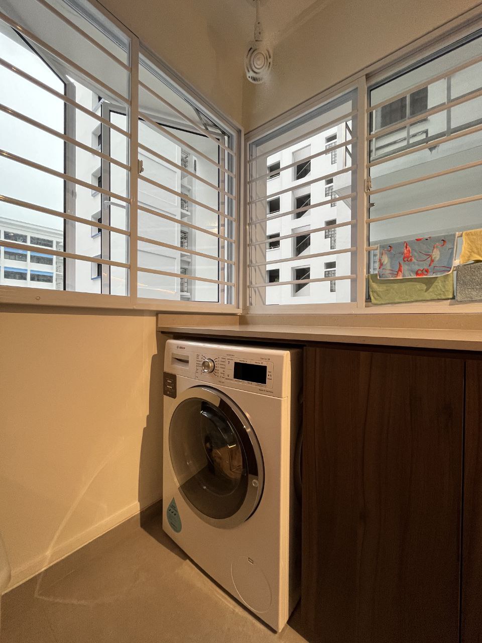 Our very long Service Yard - Modern laundry room with built-in washer and dryer, large windows with horizontal blinds, beige