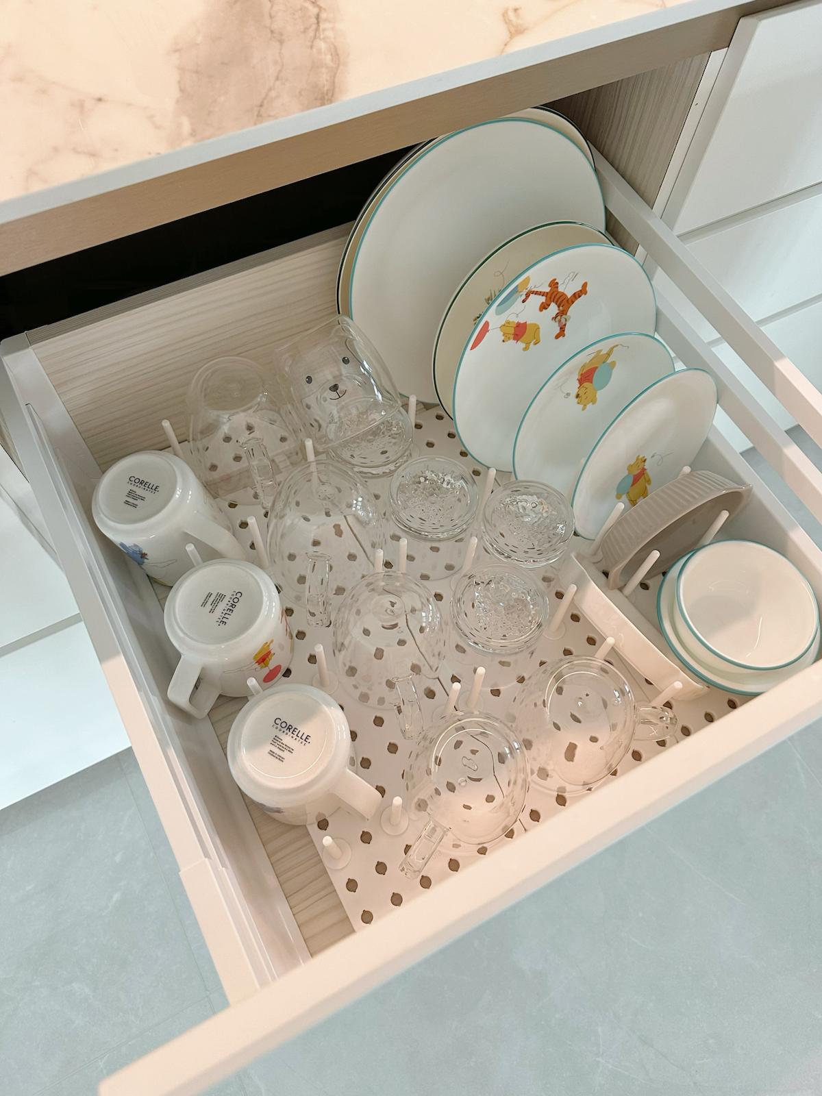 Kitchen Organisation: Tidy & practical - Clear glassware, white plates with colorful designs, ceramic mugs, glass cups