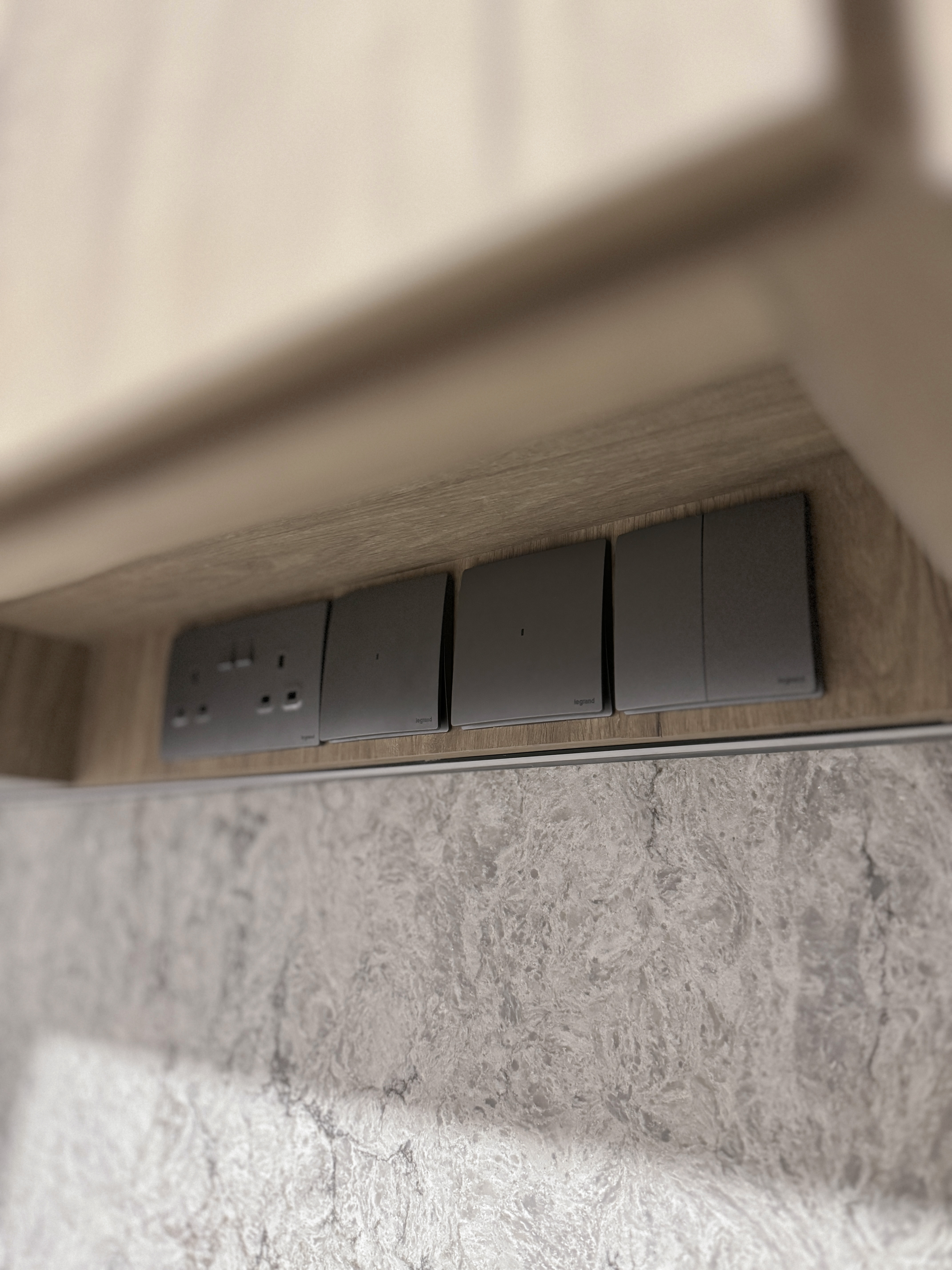 Cost Saving and Practical Tips for Organizing an Open Kitchen - Underneath the wooden cabinet, four sleek, gray power strips