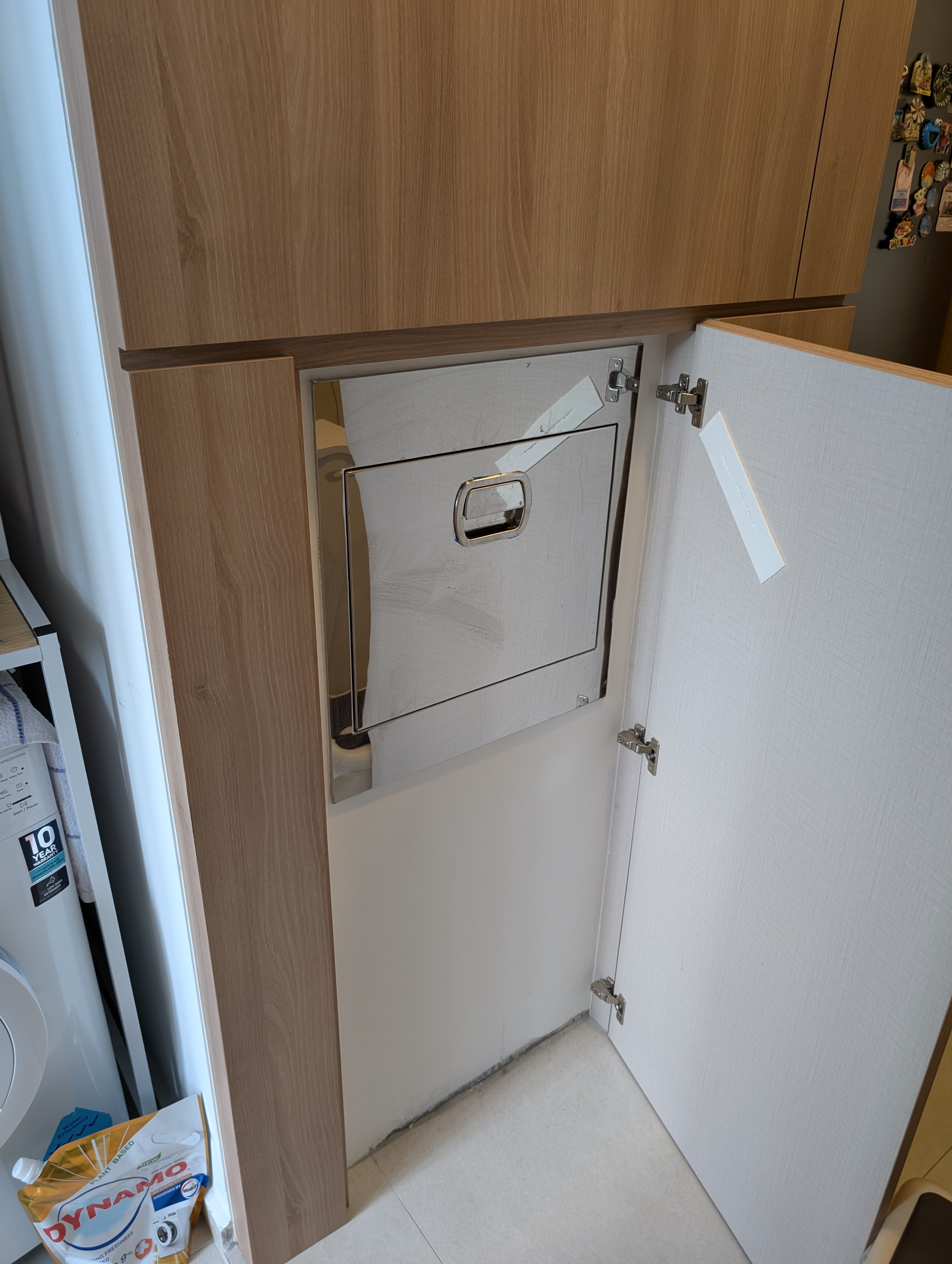 Our most unaesthetic post ever 😆 - Wooden cabinet door, white interior, metal handle, white paper tag, light gray wall