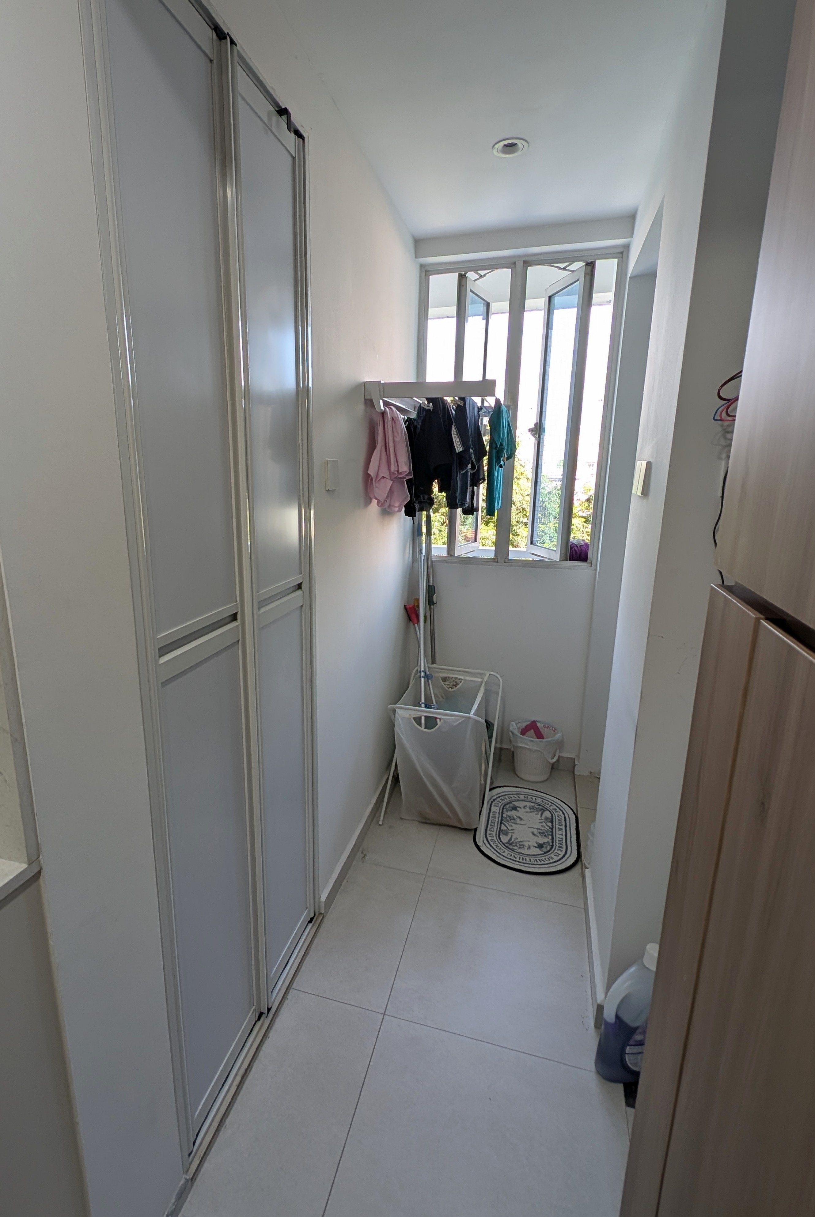 Our most unaesthetic post ever 😆 - White tiled walls, light-colored floor, clothes rack with various garments, wooden