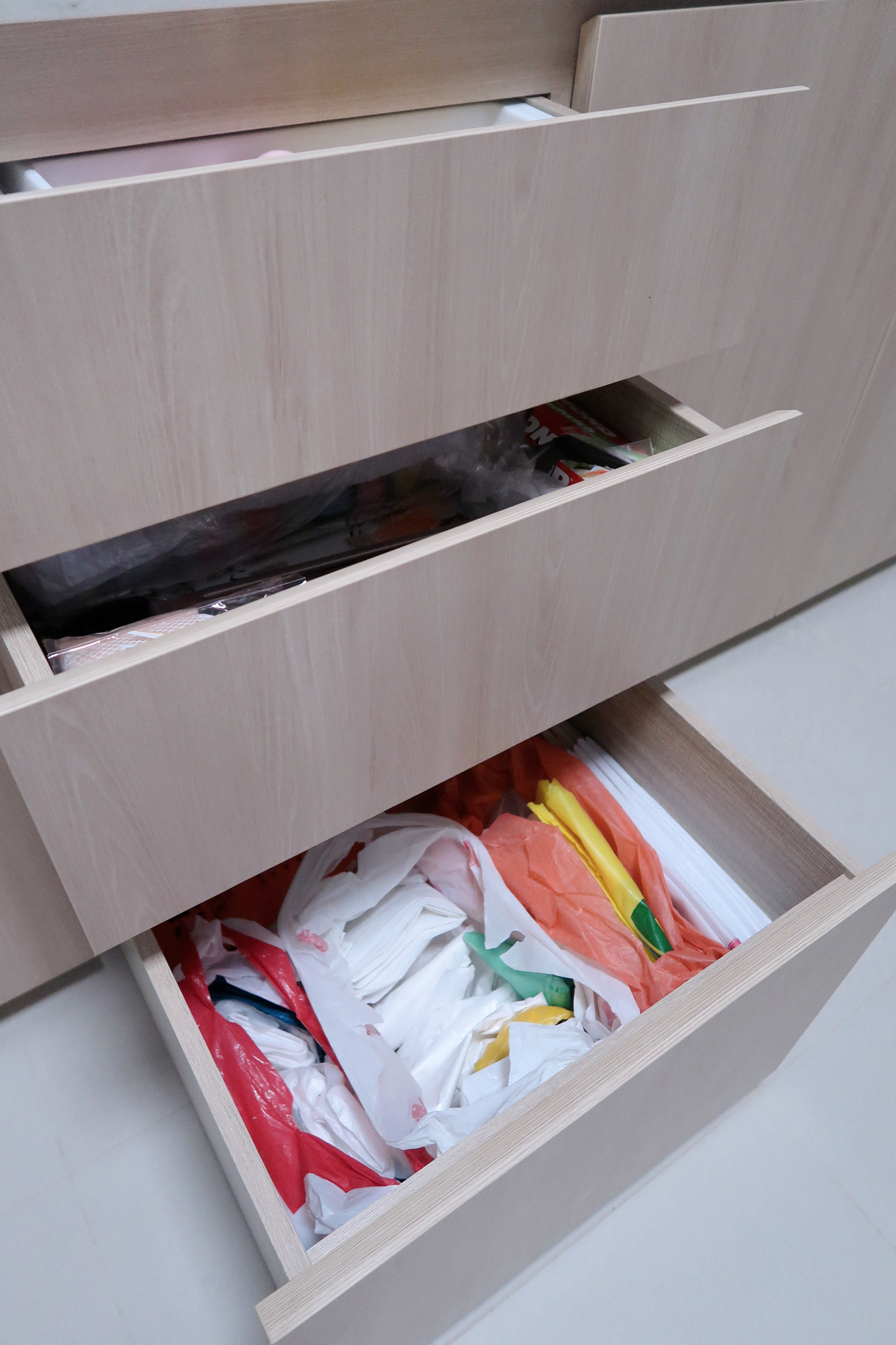 Our Enclosed Kitchen Organisation With Plenty Storage  - Wooden drawer, open, cluttered, plastic bags, colorful items