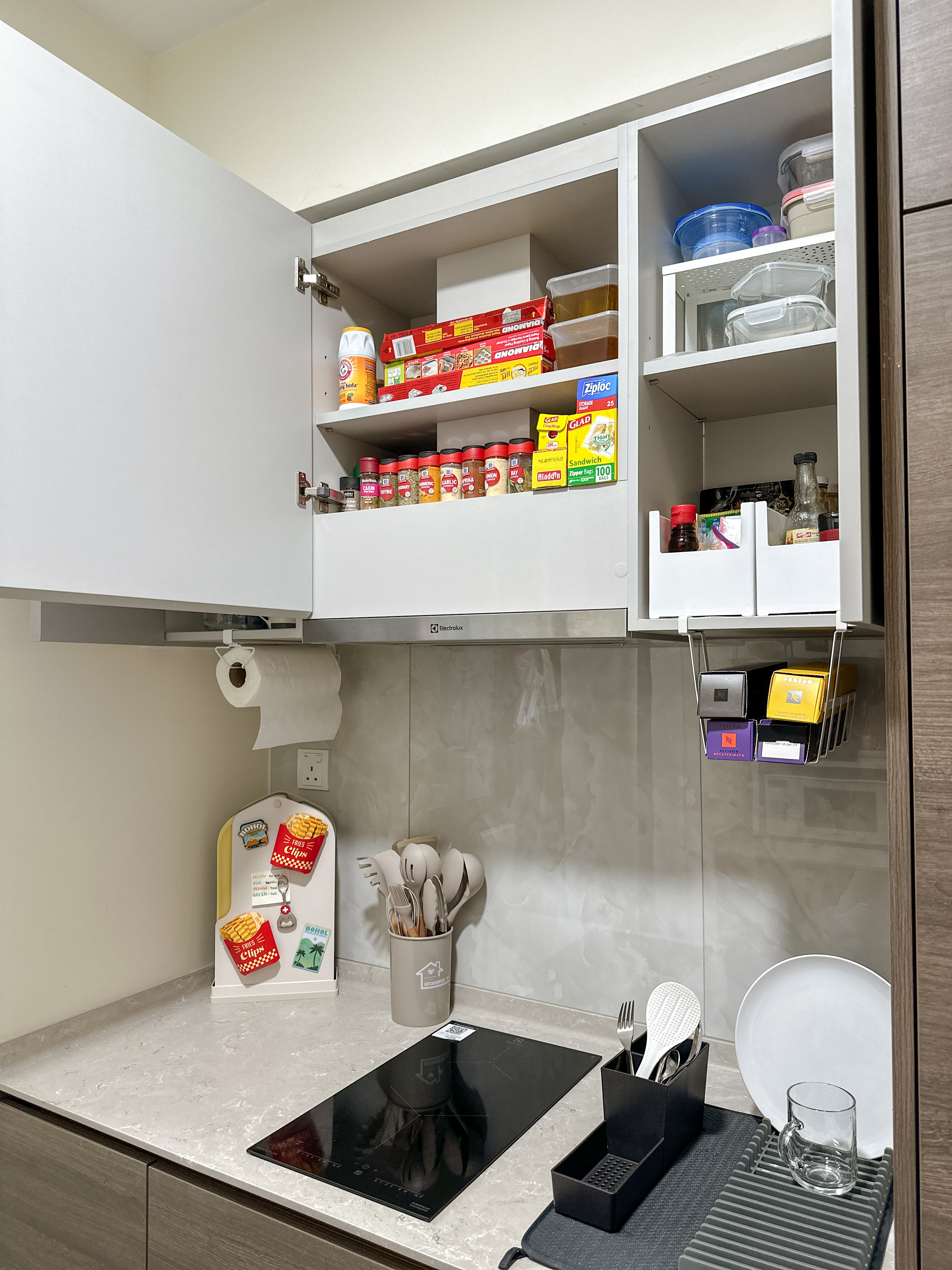 A little tour of our kitchen organizers! ✨ - Kitchen cabinet with various food items, spice jars, and utensils, neatly