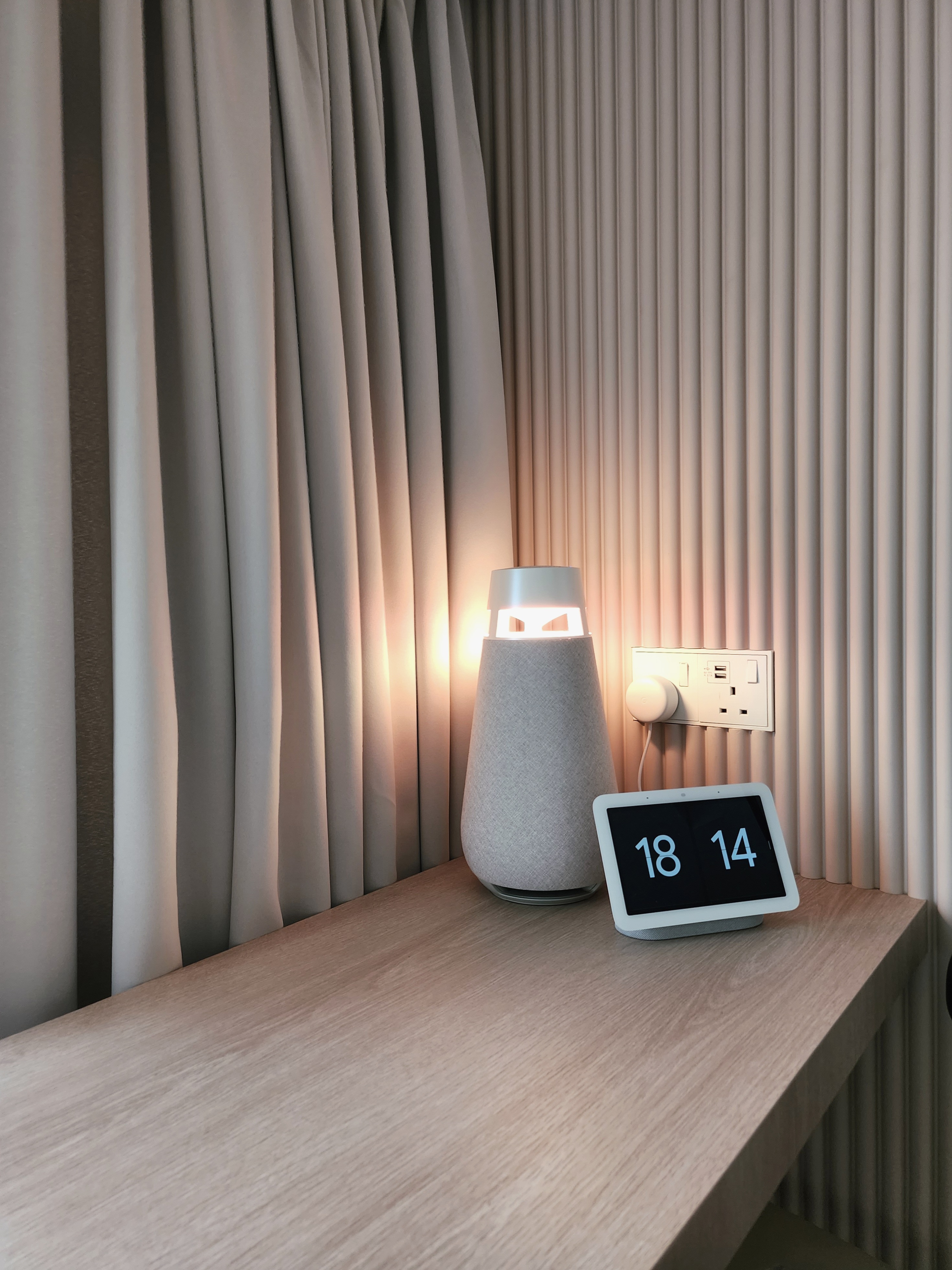 Our Cosy Corner: A Nook By The Window  - Soft, neutral-toned curtains, modern lamp with glowing base, digital clock