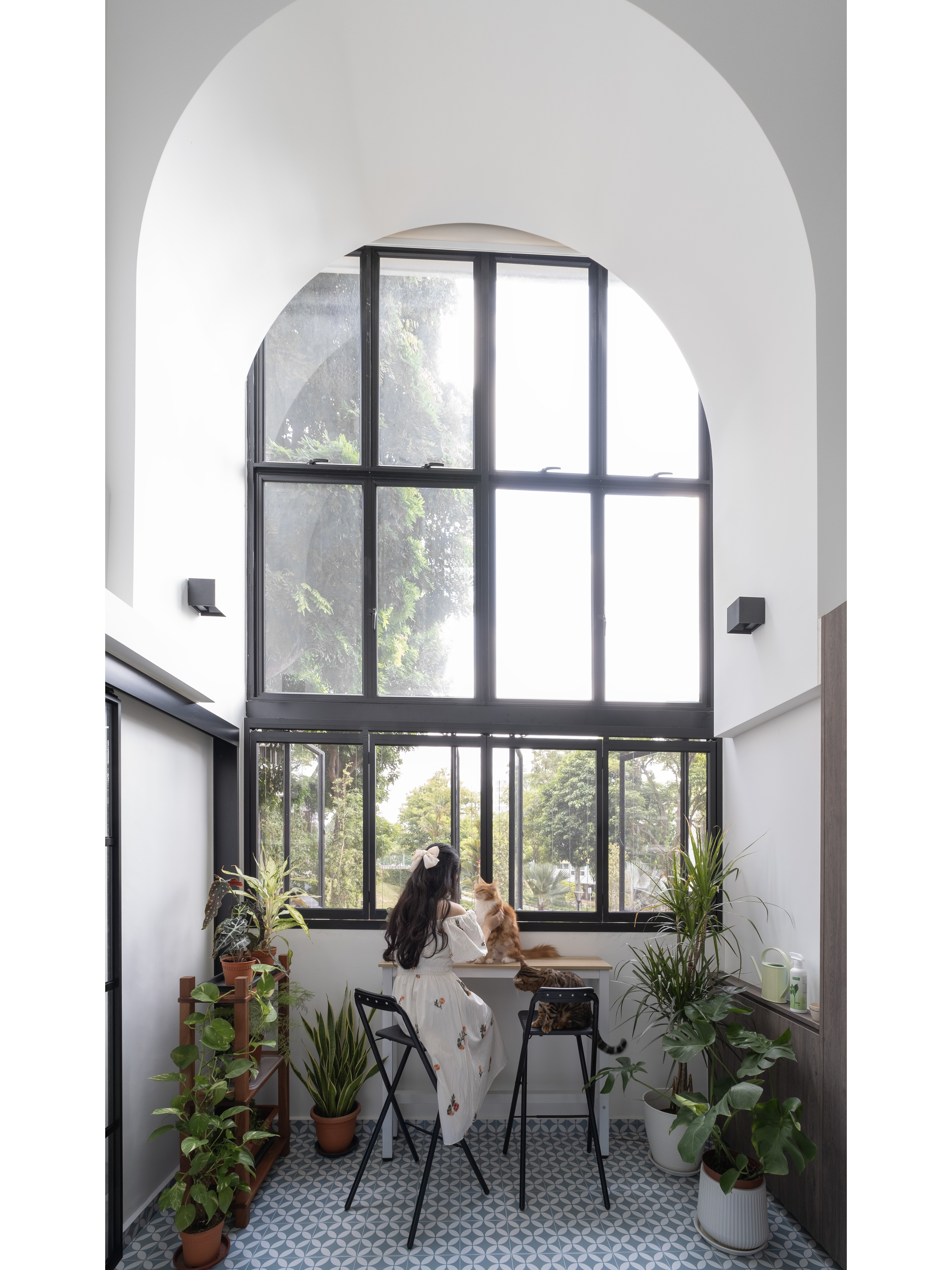 Café Vibes at Home in this Stunning High-Ceiling Balcony - Large windows, indoor plant, cat, woman with long hair, sitting at