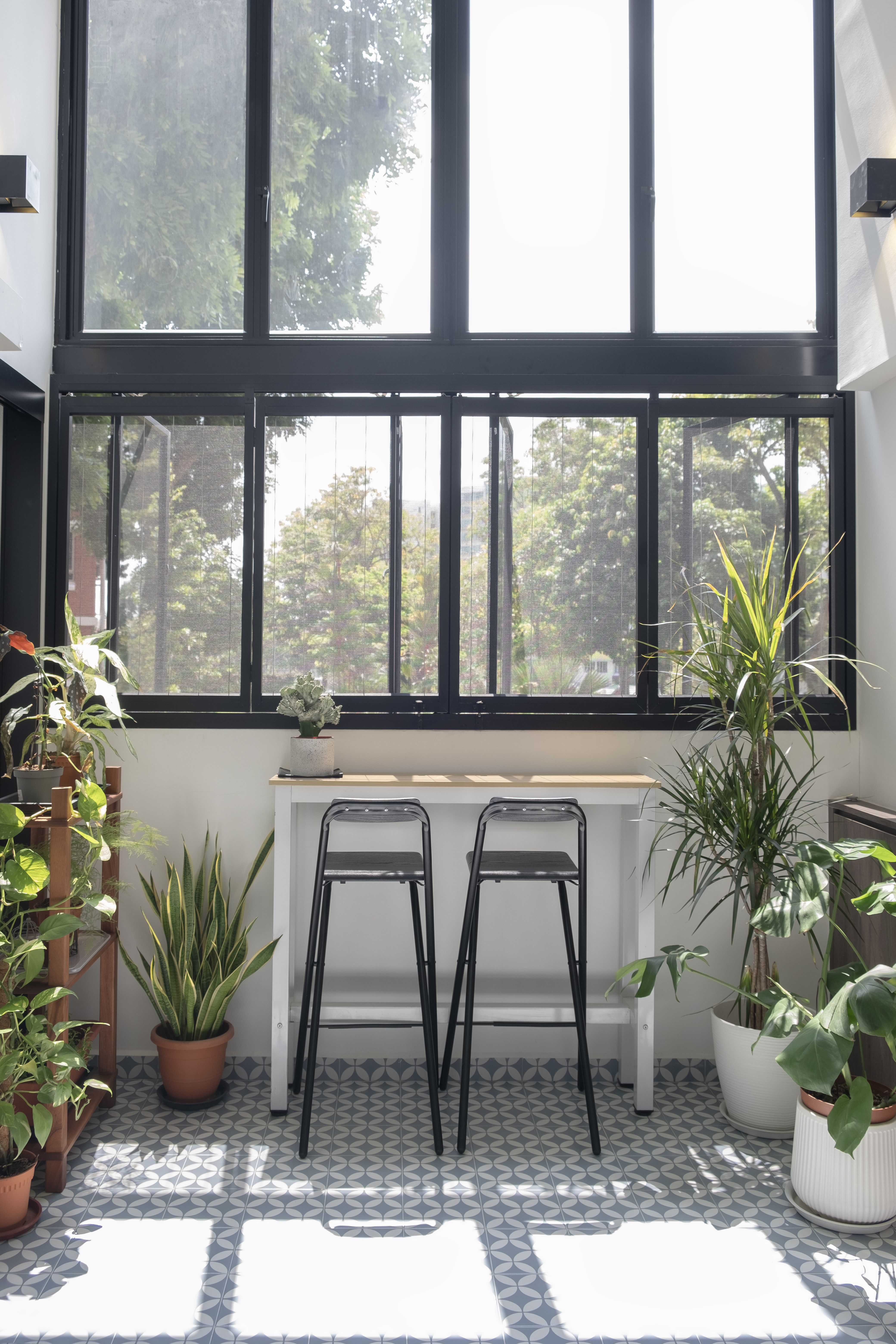 Café Vibes at Home in this Stunning High-Ceiling Balcony - Large windows, natural light, indoor plants, geometric pattern
