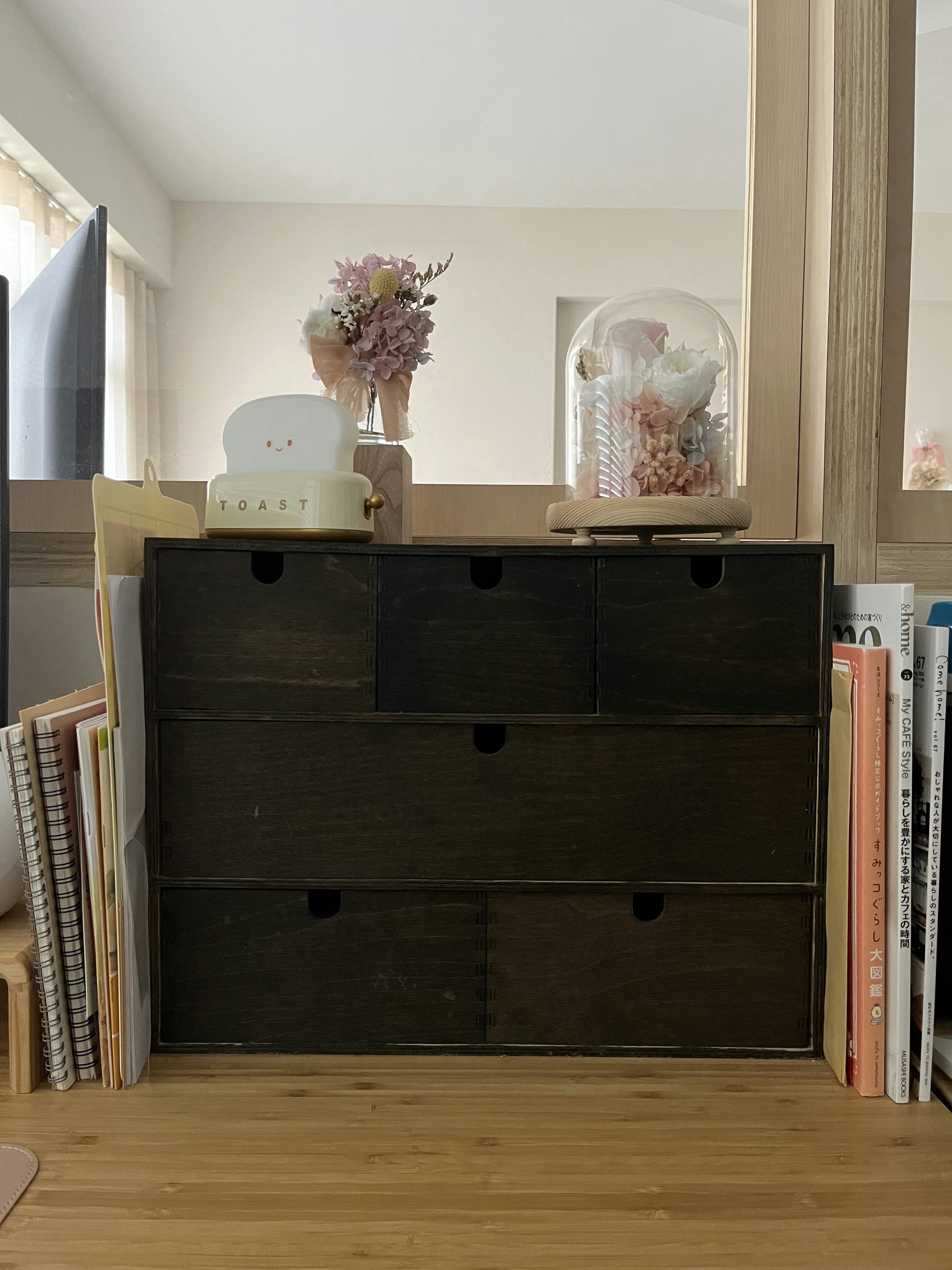 How I organise my desk  - dark wooden dresser, neatly organized, minimalist decor, soft natural light, pastel flowers, wooden