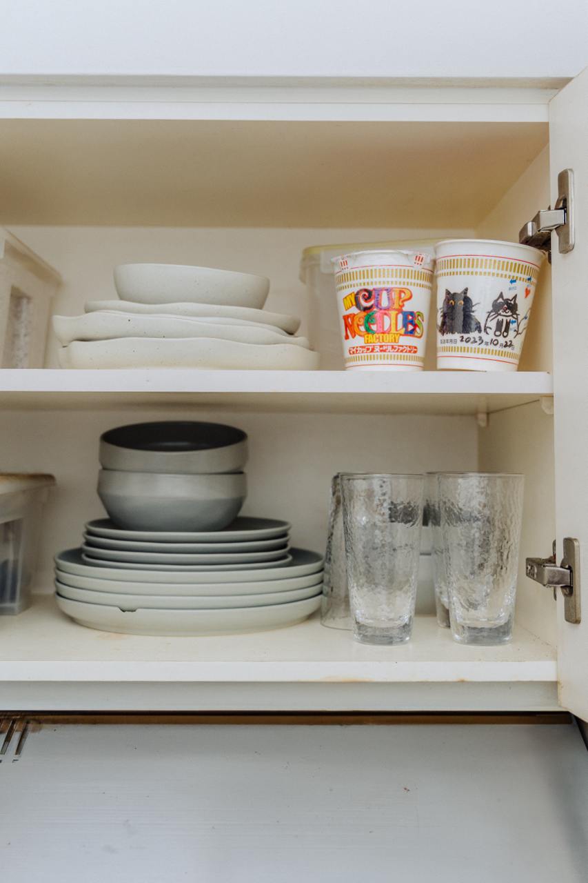 Tiny Kitchen Living: Organisation Tips To Live Mess Free - ceramic dishes, stacked plates, glassware, clear glasses, white