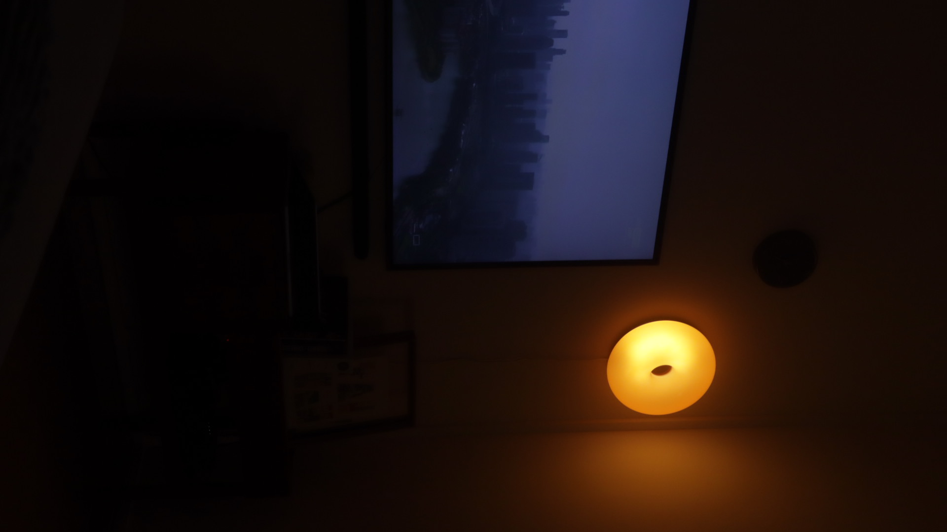 (chair, book, light) maketh nook : trinity to a cosy corner  - dimly lit room, dark ceiling, small light fixture, glowing