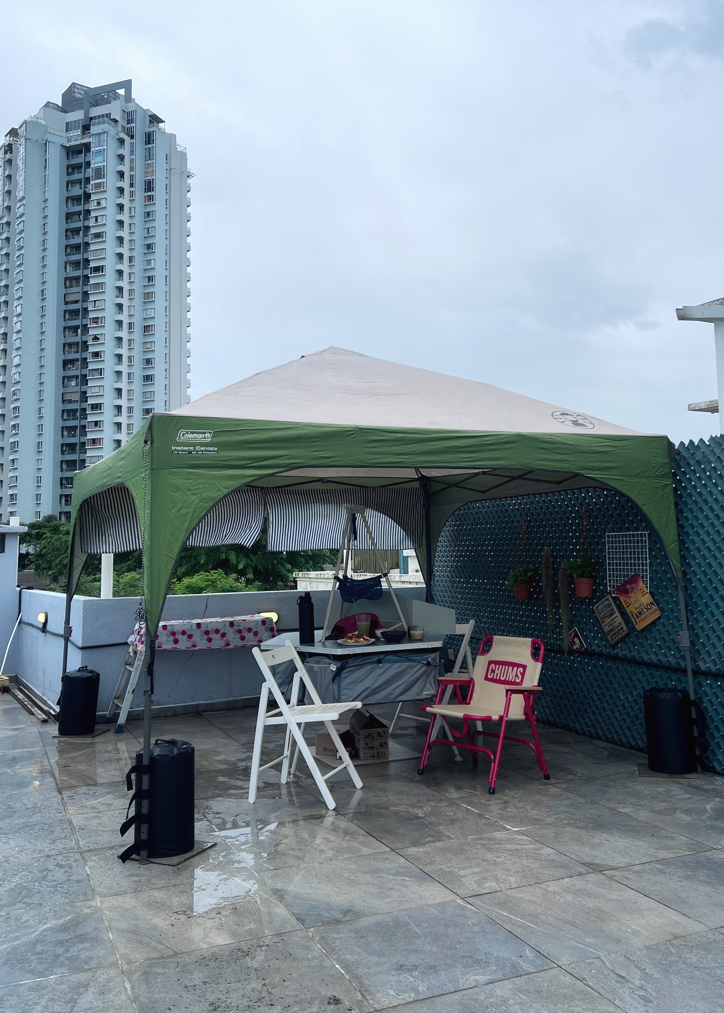The roof is on FIRE!! 🔥🔥🔥 - Green and white canopy tent, rooftop patio, patio furniture, white folding chairs, pink