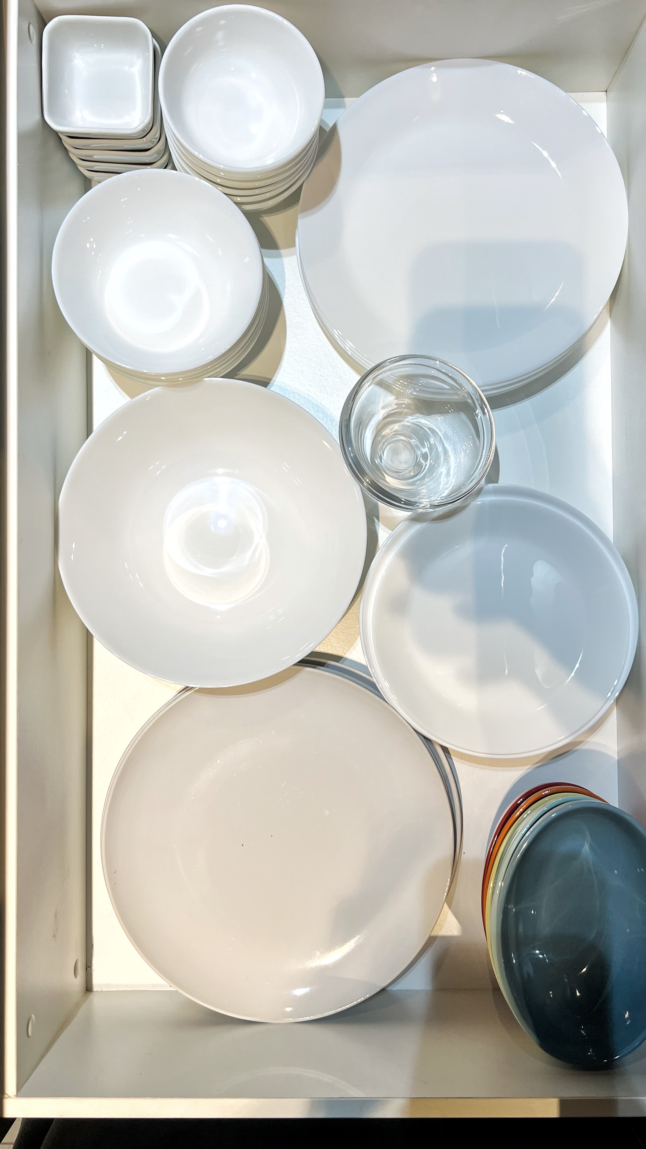 From Clutter to Calm: Transforming with Thoughtful Organization - White ceramic plates, glass bowl, stacked plates, empty