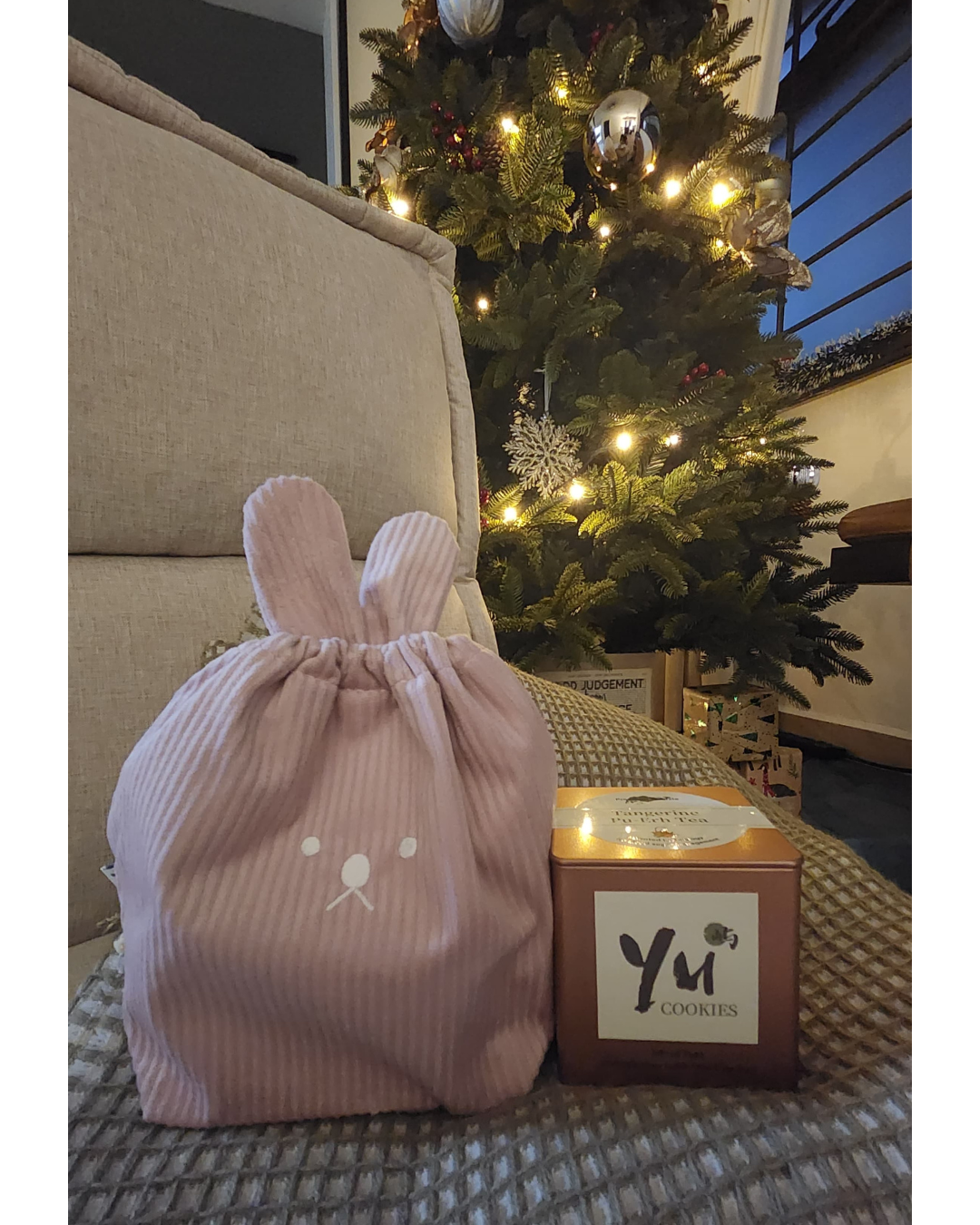Hosting at Home: From 2 to 22  - Christmas tree, festive decorations, cozy living room, wrapped presents, pink bunny bag, tea