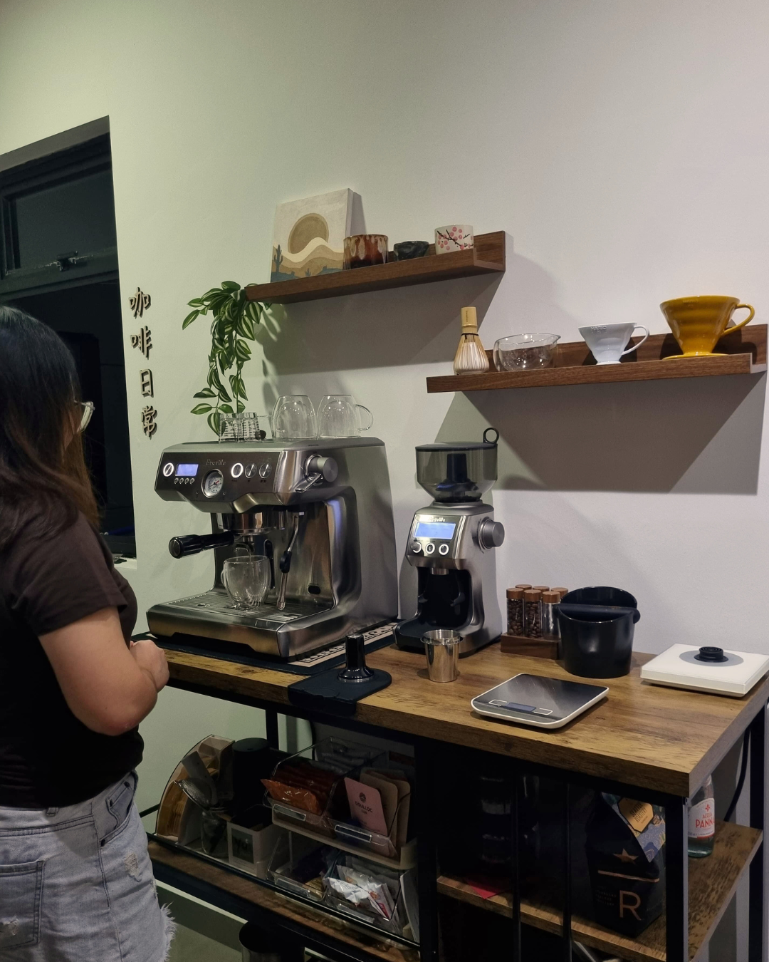 Hosting at Home: From 2 to 22  - woman standing next to coffee machines, coffee beans on counter, coffee grinder, coffee