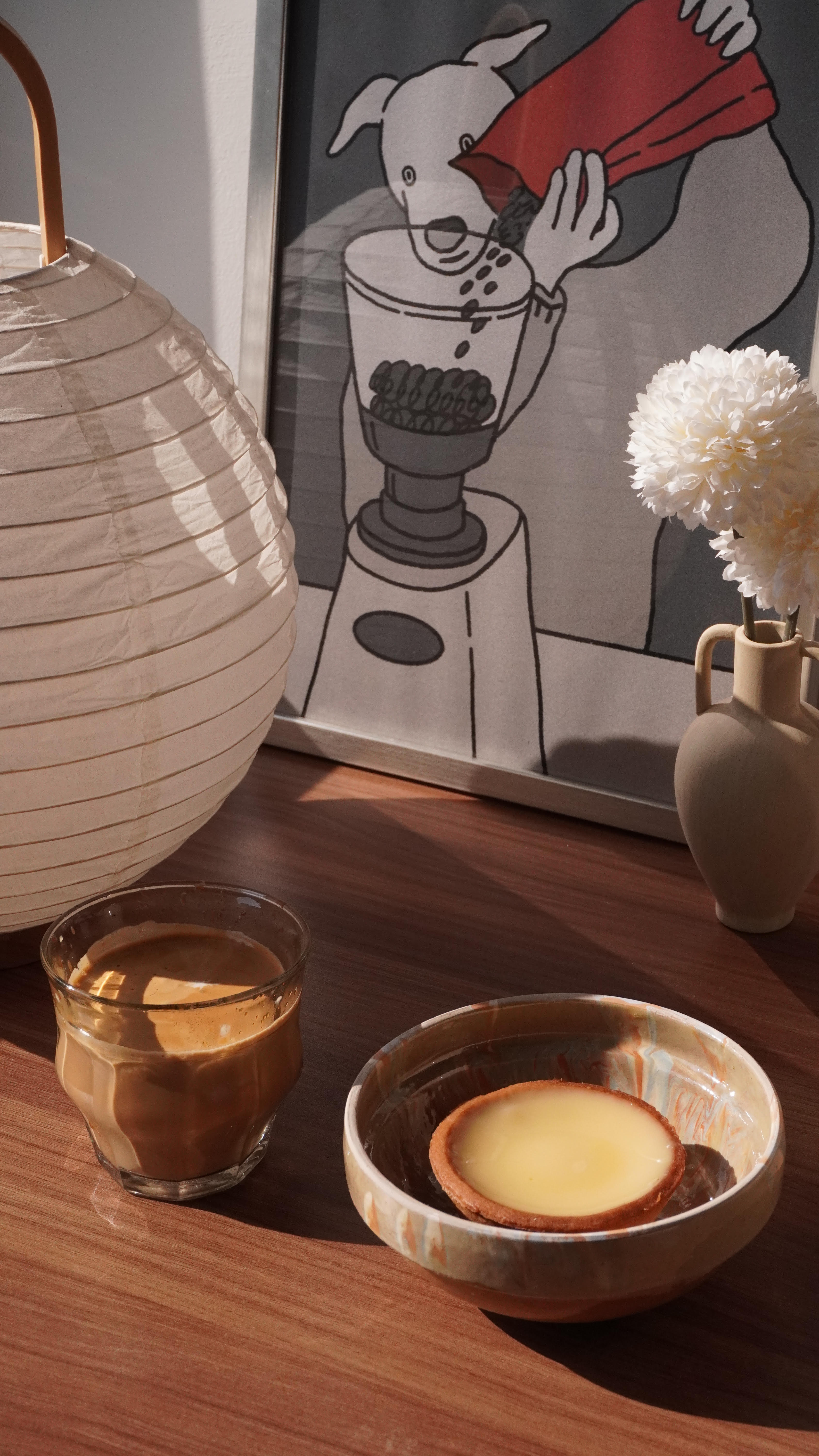 A routine that spice up your day!  - White lantern, coffee cup, glass of coffee, ceramic bowl, coconut, white flowers, wooden