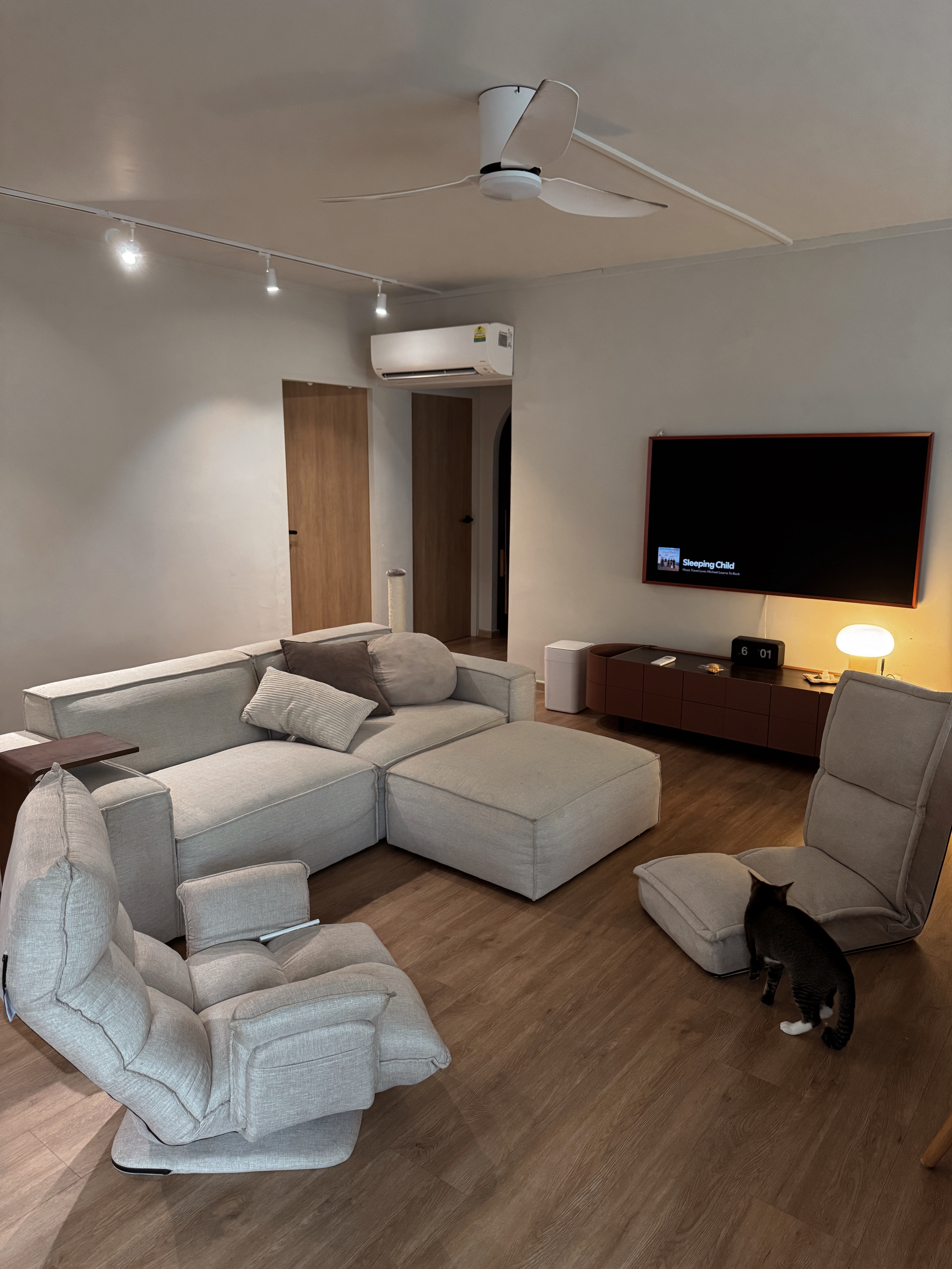 Hosting Tips to Make Guests Feel at Home - Modern living room with beige sectional sofa, wooden coffee table, and floor lamp.