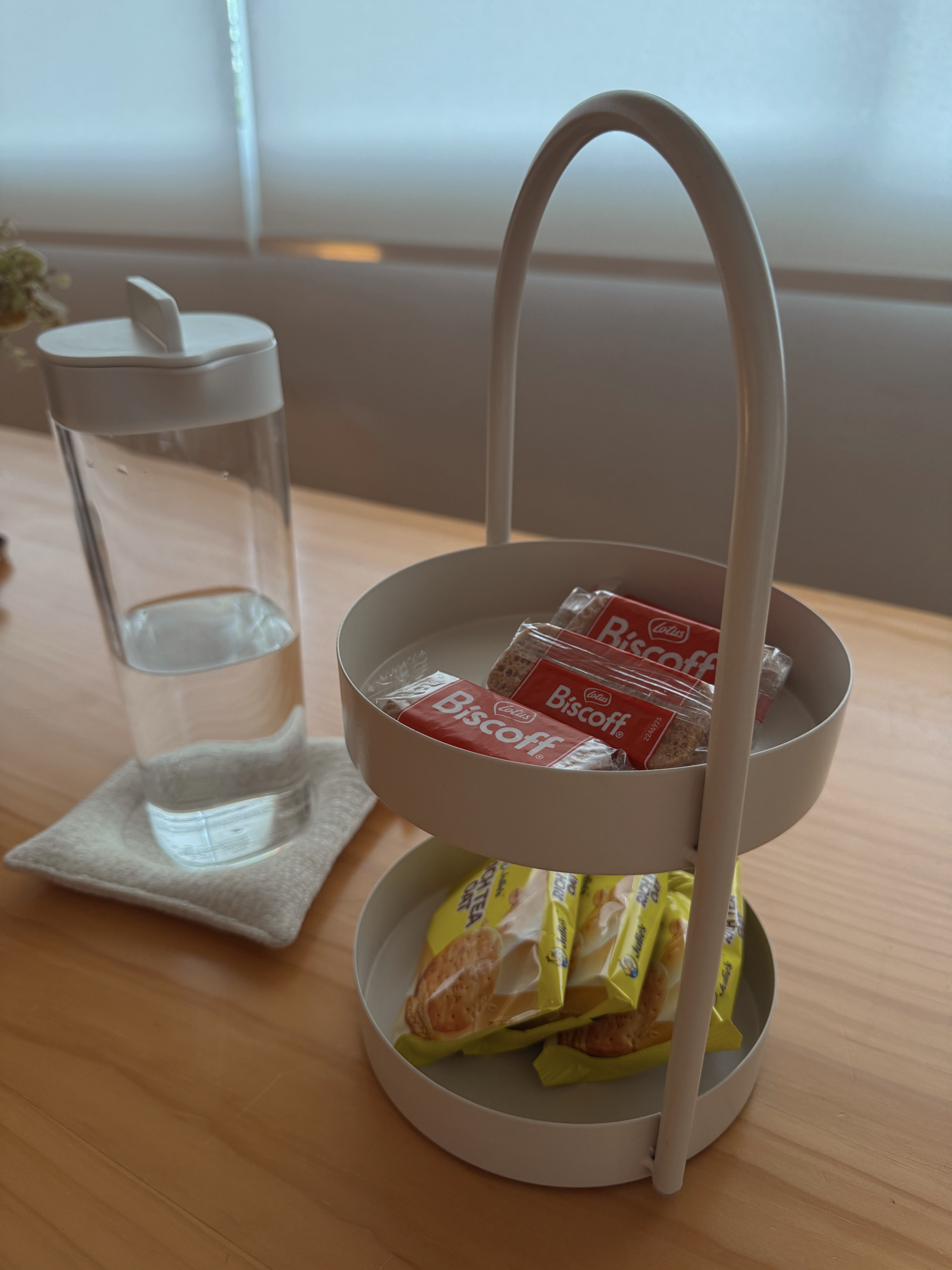 Hosting Tips to Make Guests Feel at Home - glass of water, white cup, napkin, Biscoff cookies, yellow packaging, tea bags