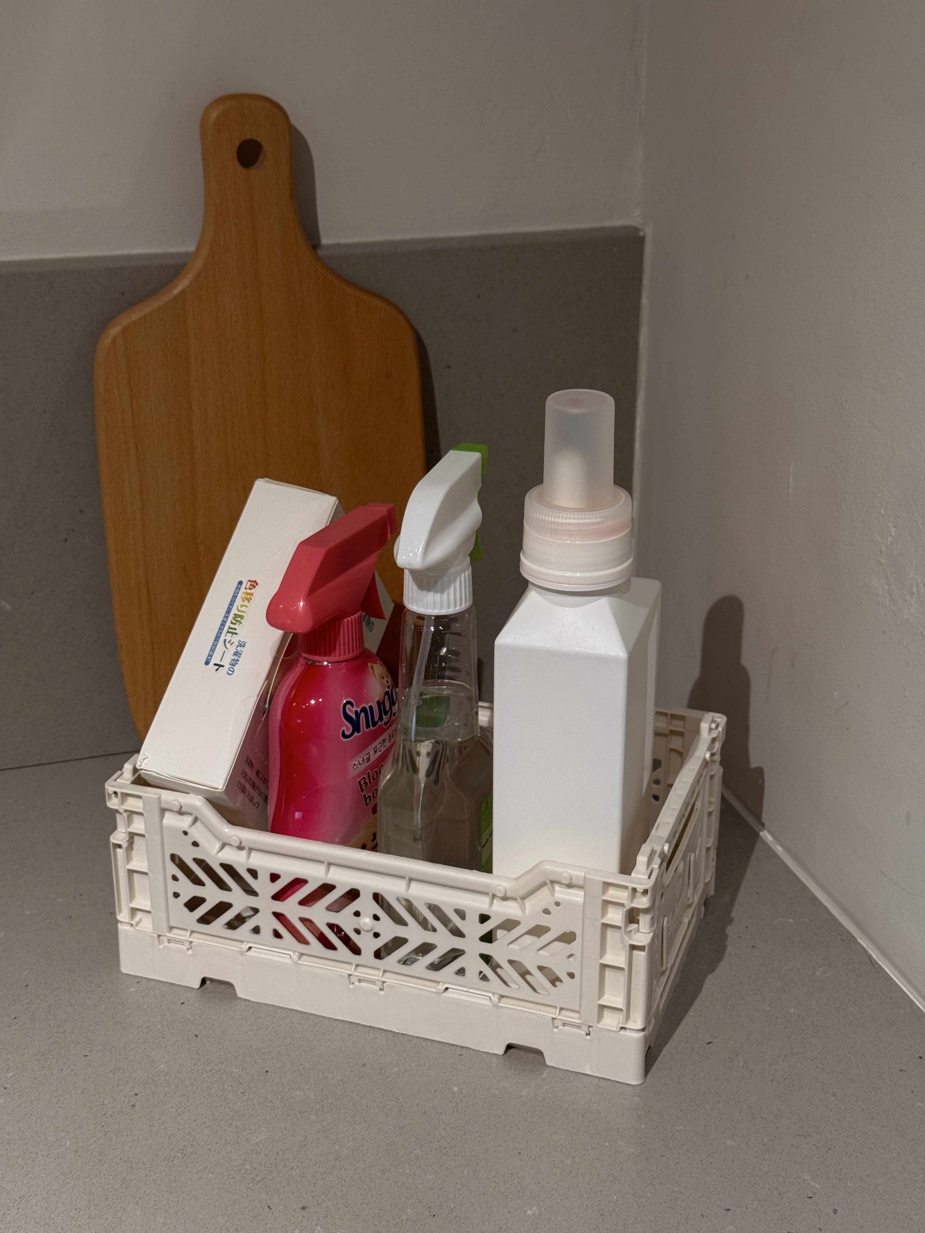 Home Organization We Love - Wooden cutting board, white plastic crate, kitchen counter, small bottle, spray bottle, soap