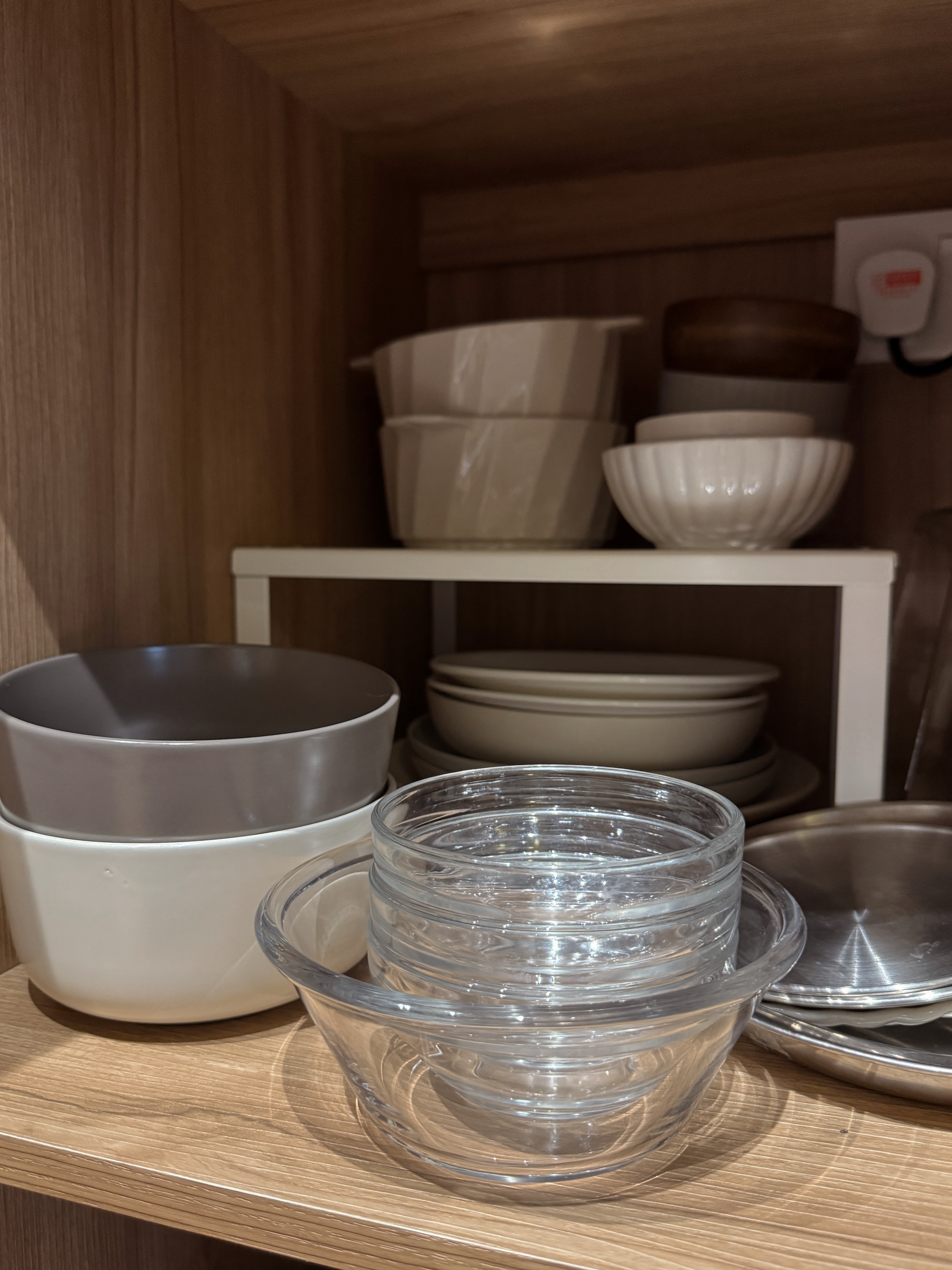 Home Organization We Love - Clear glass bowls, wooden shelf, neatly organized dishes, white ceramic bowls, stainless steel