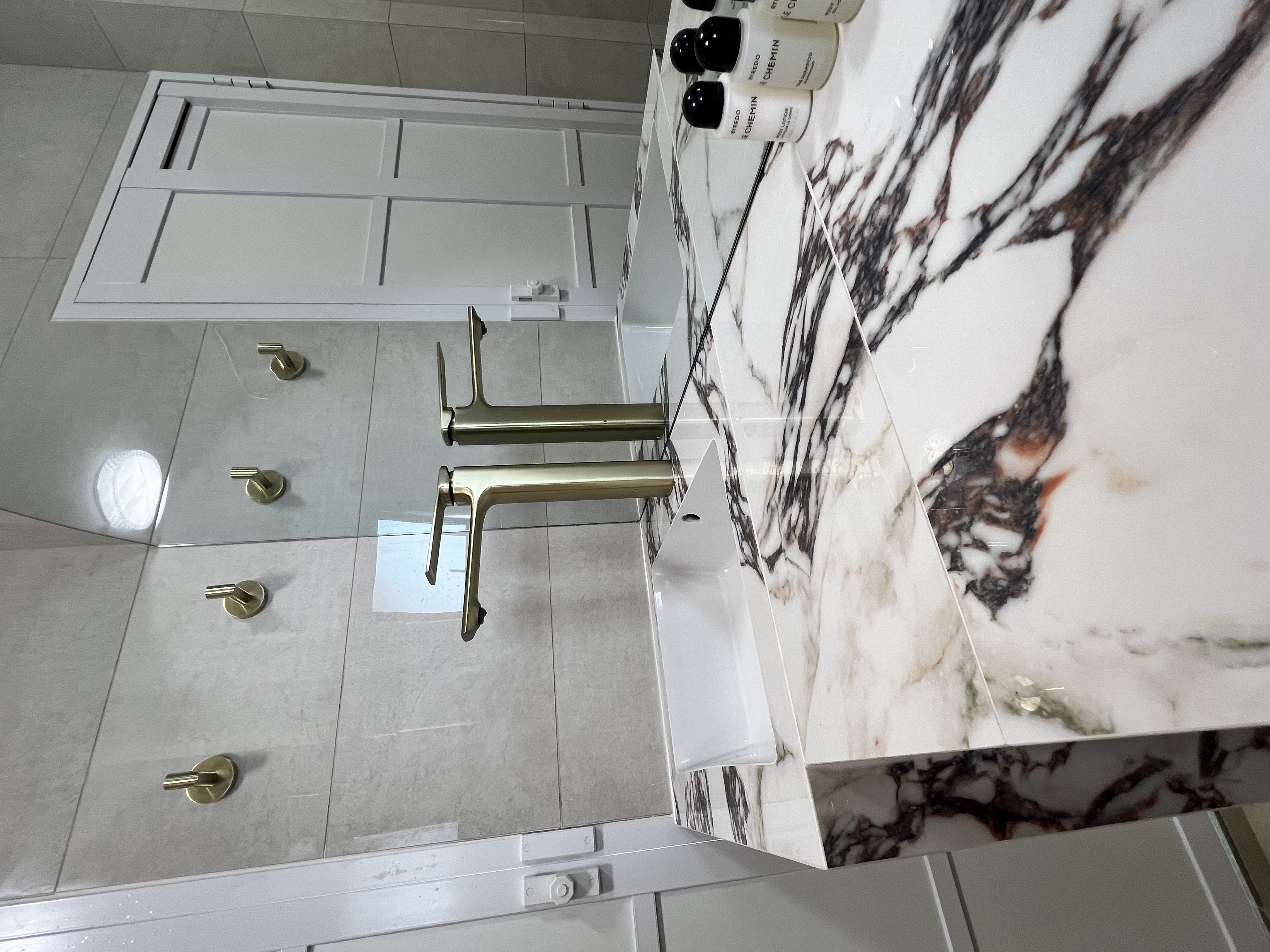 Desert Dreams: A Dune-Inspired Oasis with a Bold Vanity! - White marble countertop, gold faucet, modern bathroom design