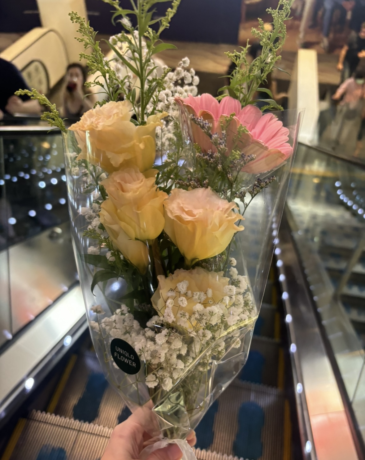 Our simple weekend routine 💖 - vibrant bouquet of yellow and pink flowers, elegantly wrapped in clear paper, held by a hand