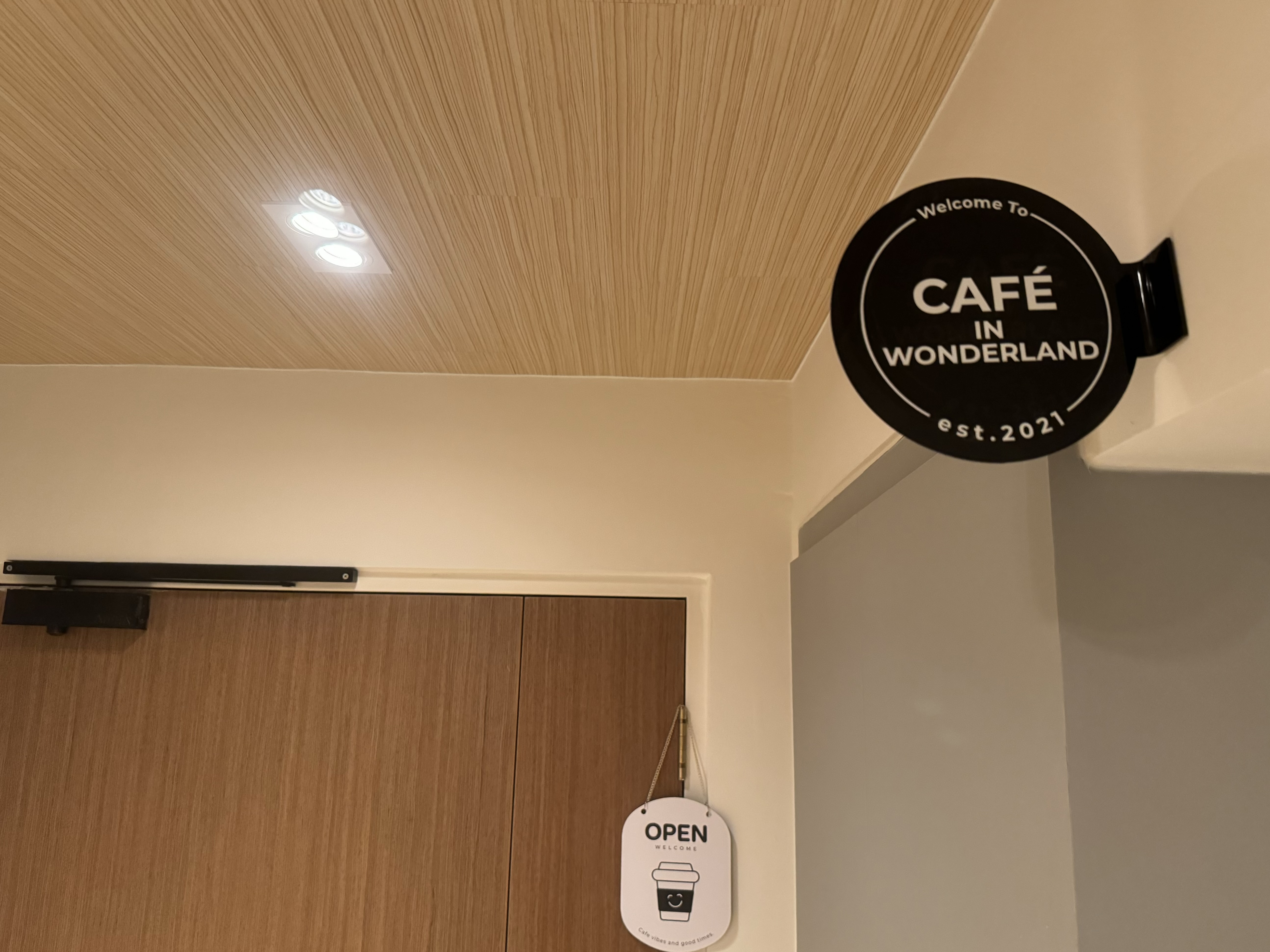 FAQ: Your Space = Your Vibes 🏠  - Wooden ceiling, recessed lighting, modern design, welcoming sign, "Welcome To CAFÉ IN